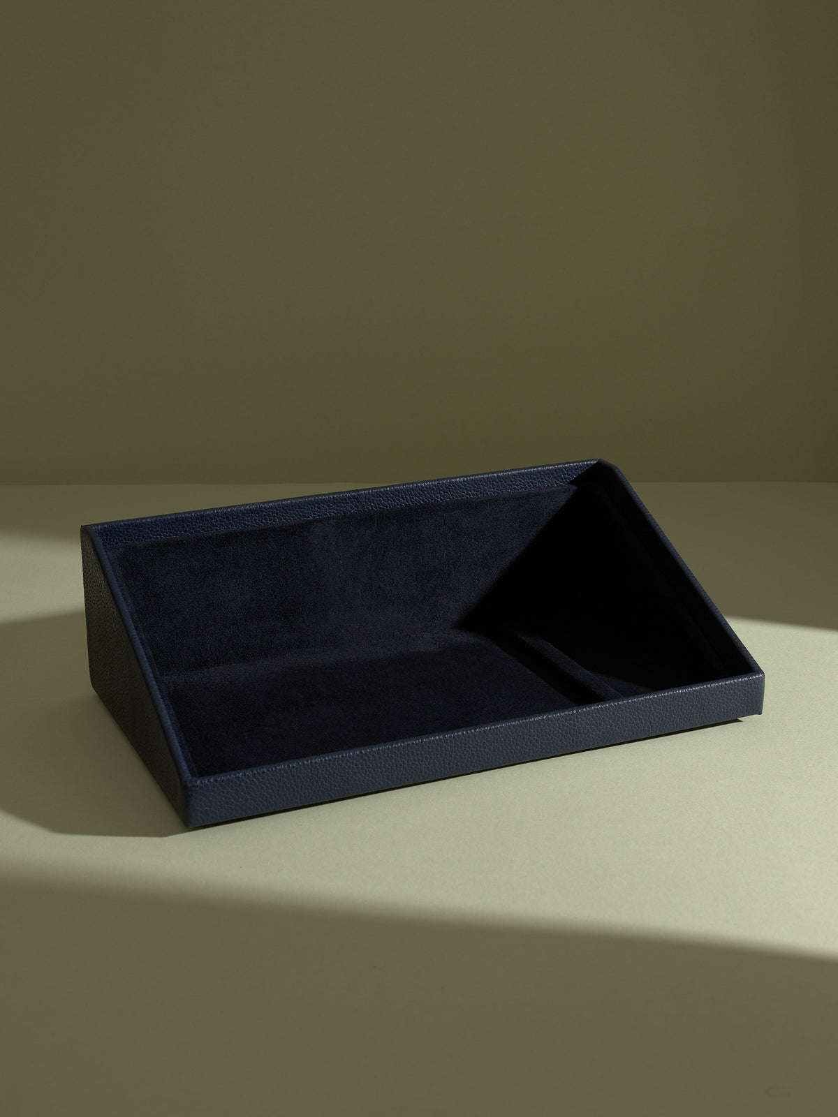 The Podium navy leather accessory drawer from the watch box stand, lined with suede.