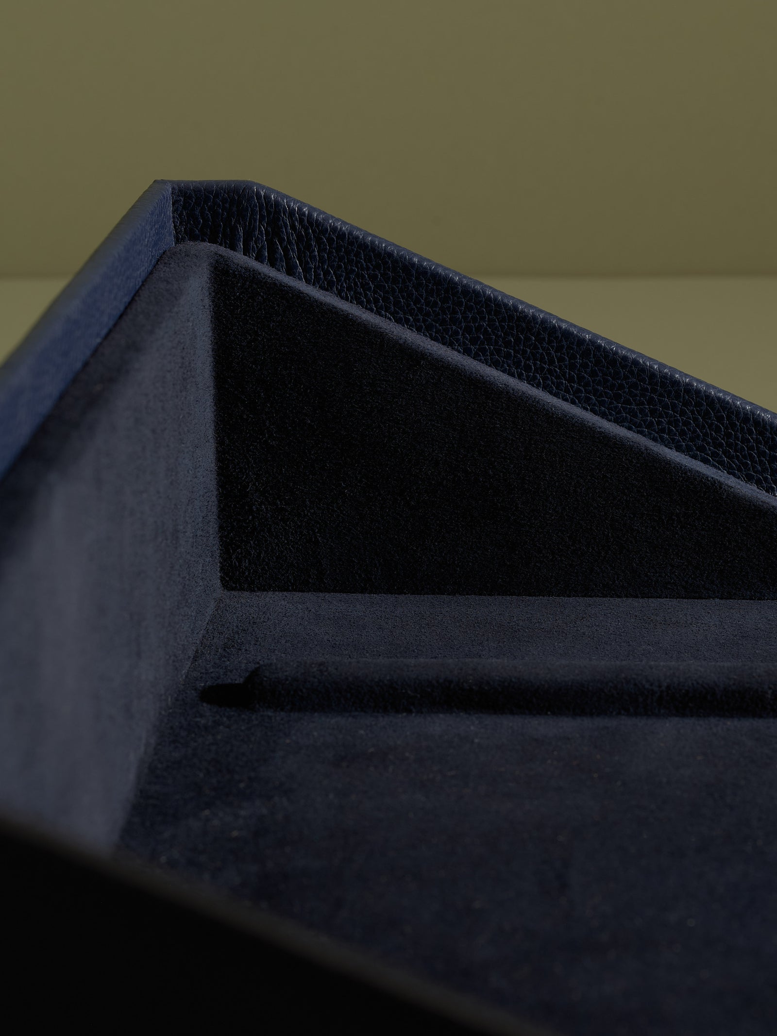 The Podium Detail of the plush velvet lining inside the navy Capra leather accessory storage drawer.