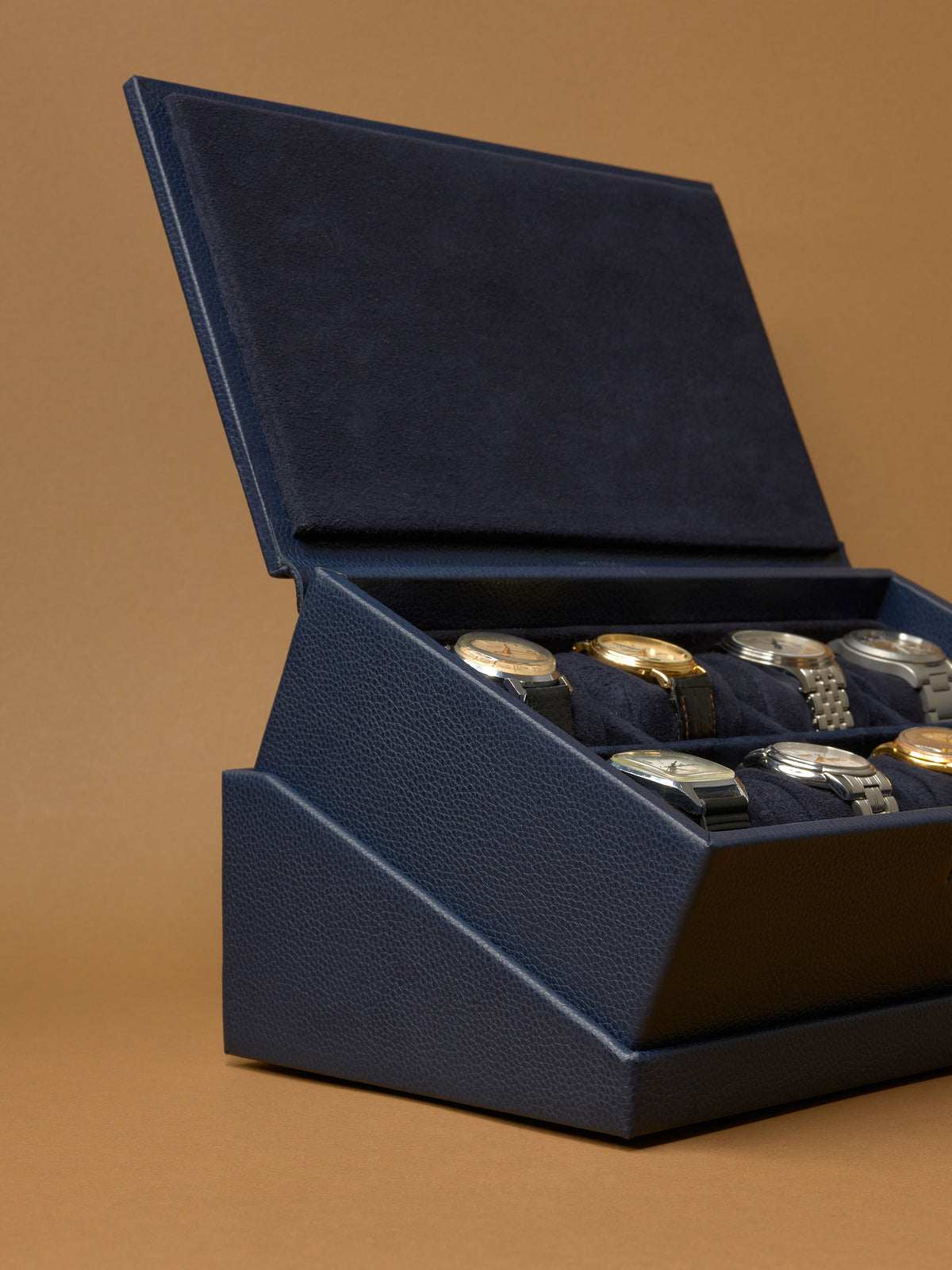 The Podium Side view of the open, slanted Capra leather watch display box on its hidden storage drawer base.