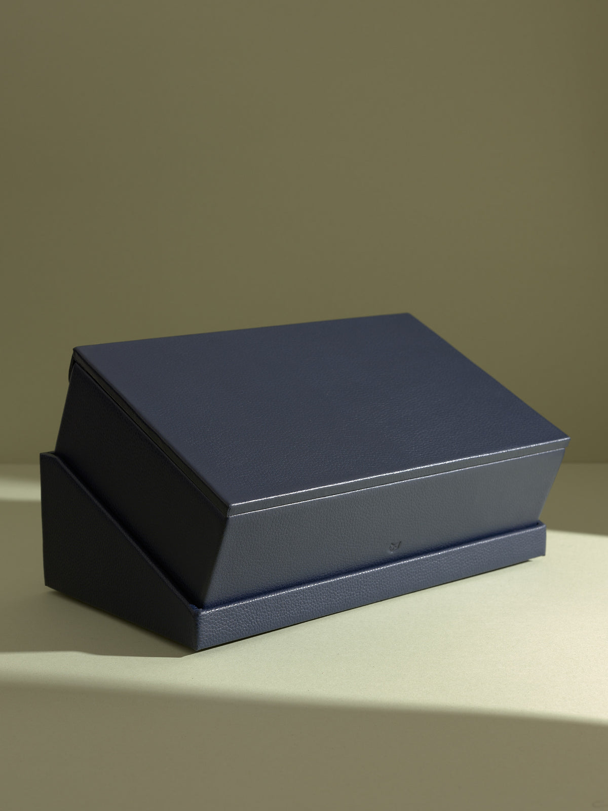 The Podium Slanted full view of the closed navy Capra leather watch box and stand, ideal for sophisticated display.