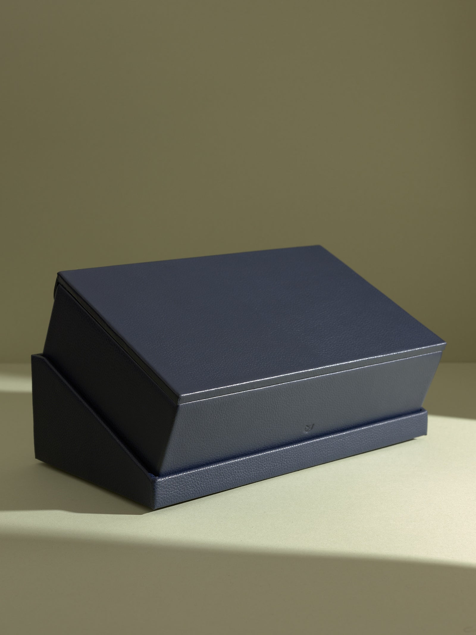 The Podium Slanted full view of the closed navy Capra leather watch box and stand, ideal for sophisticated display.
