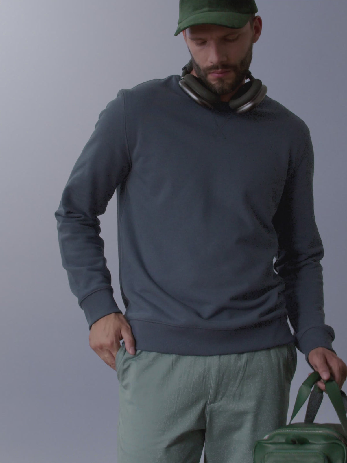 A video showcasing a man using the green leather Ventra Holdall's smart pockets, padlock loop, and shoulder strap.