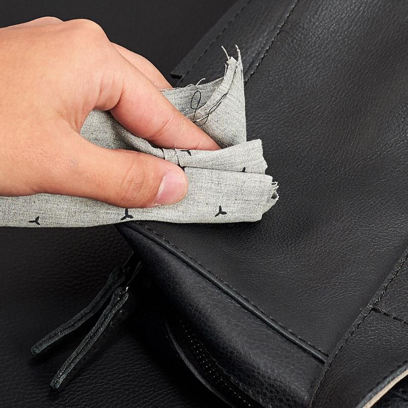 Cleaning black full-grain leather with a soft cloth