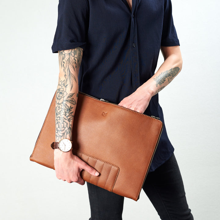 Biker tan portfolio style picture hand inside pocket. Portfolio by Capra Leather.