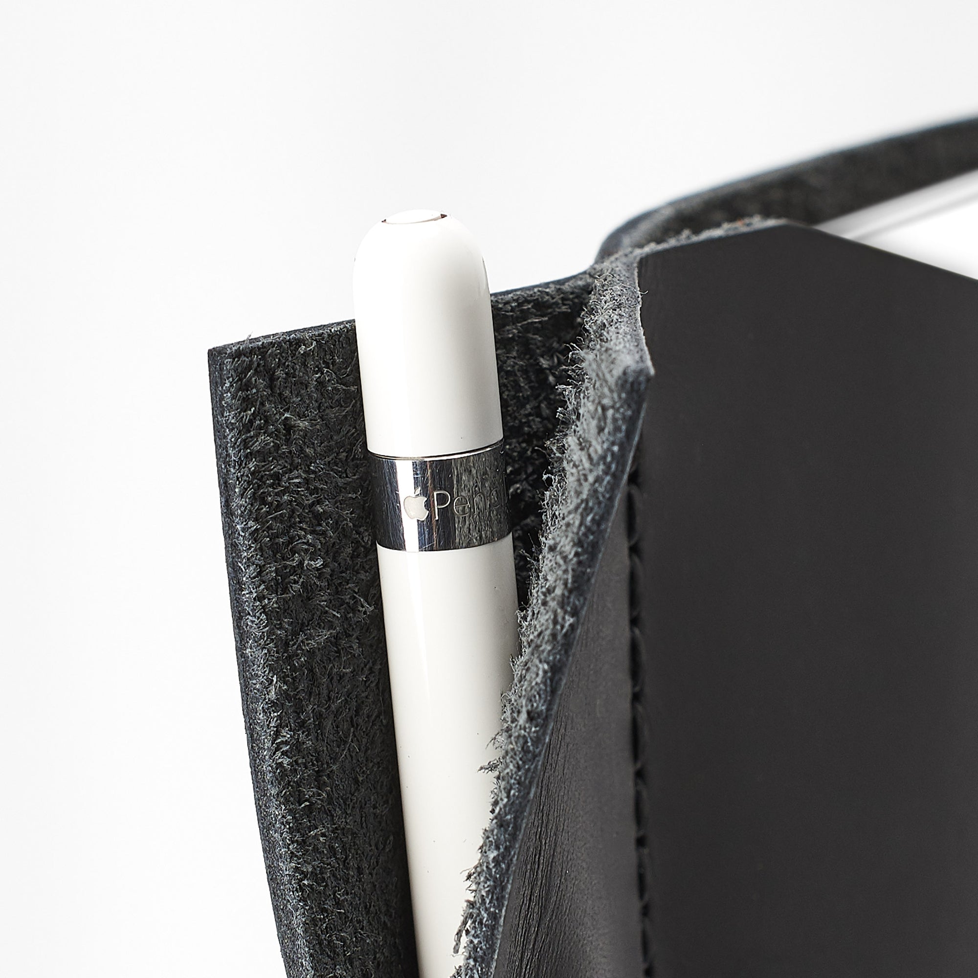 Apple pencil detail. Black iPad pro leather case with pen holder. Soft leather interior