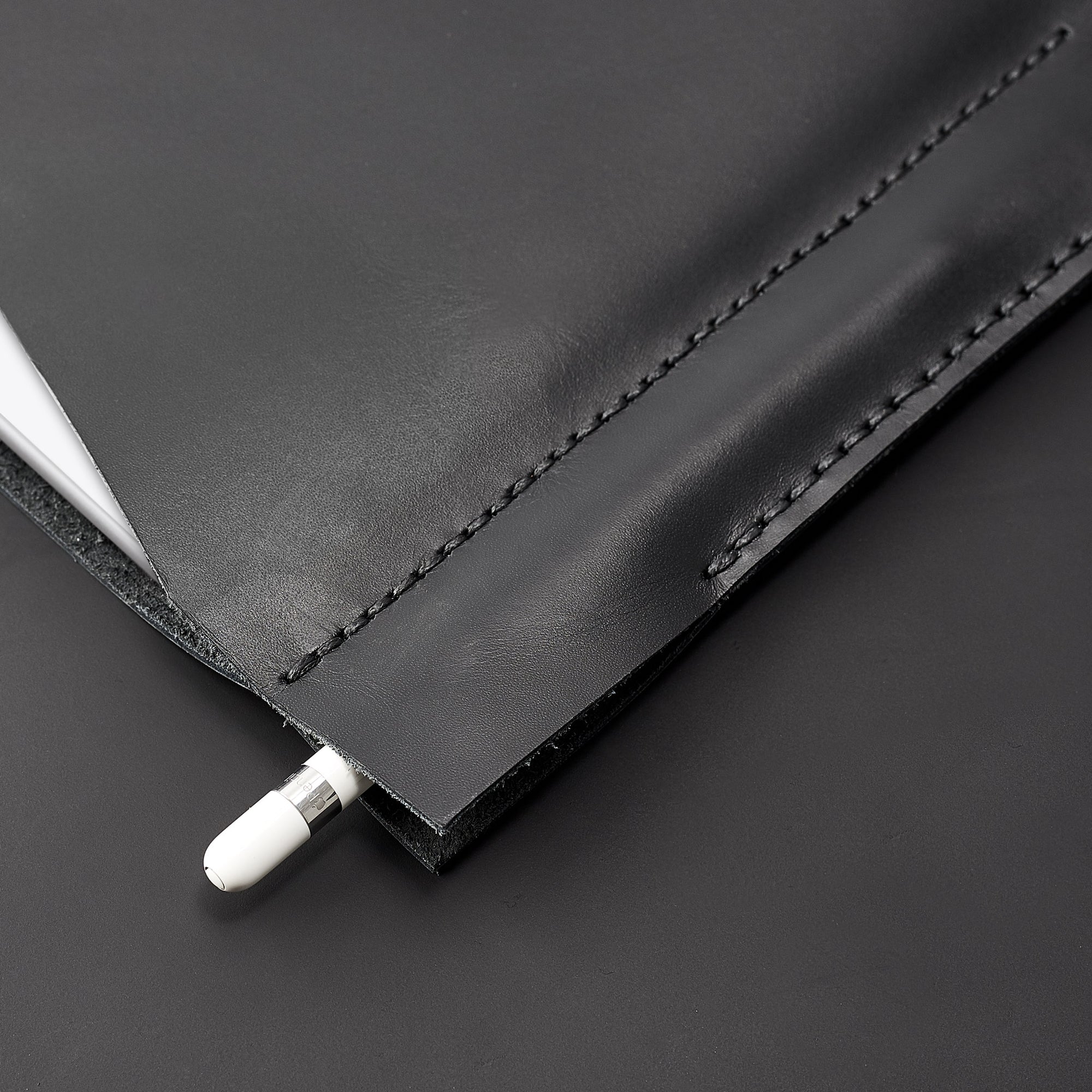 Apple pencil detail. Black iPad pro leather case with pen holder. Soft leather interior