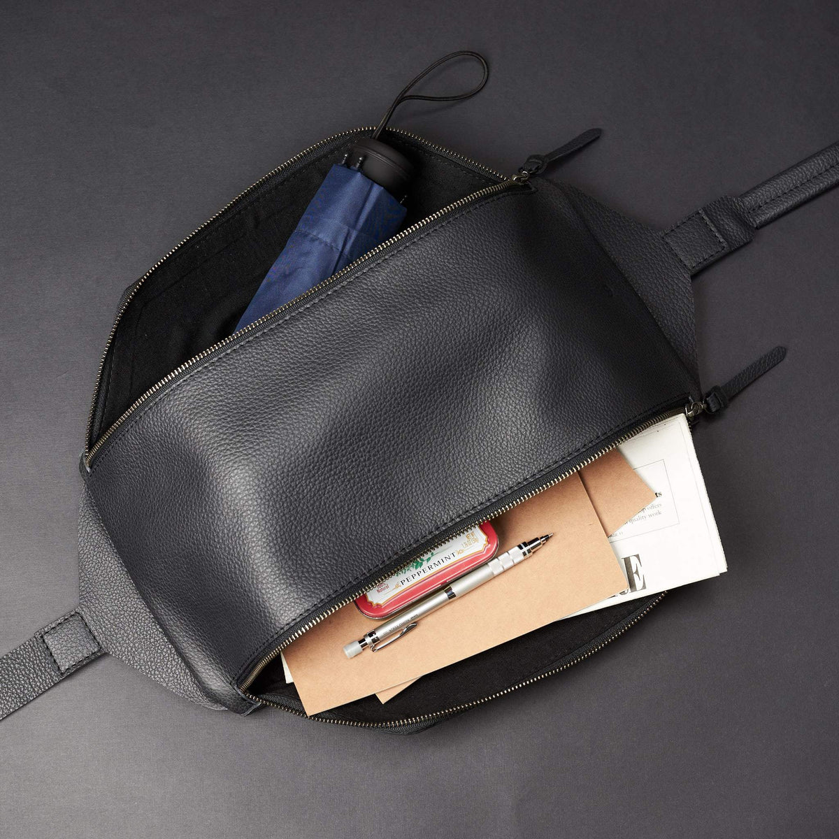 Black Fenek sling bag backpack made by Capra Leather. Styling medium and small compartment. Over the shoulder festival leather backpack. 