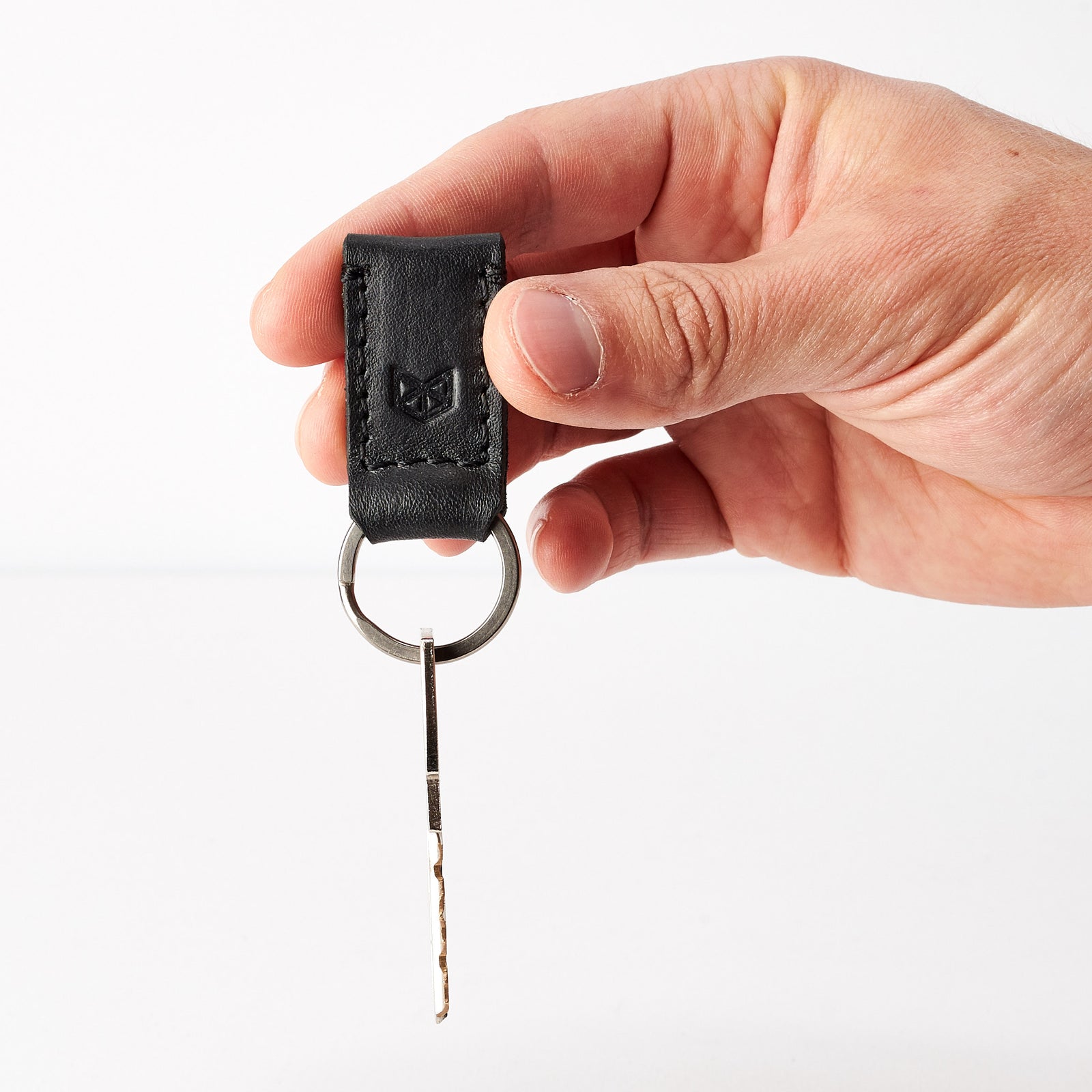 Style photo. Black leather keychain, custom magnetic key fob