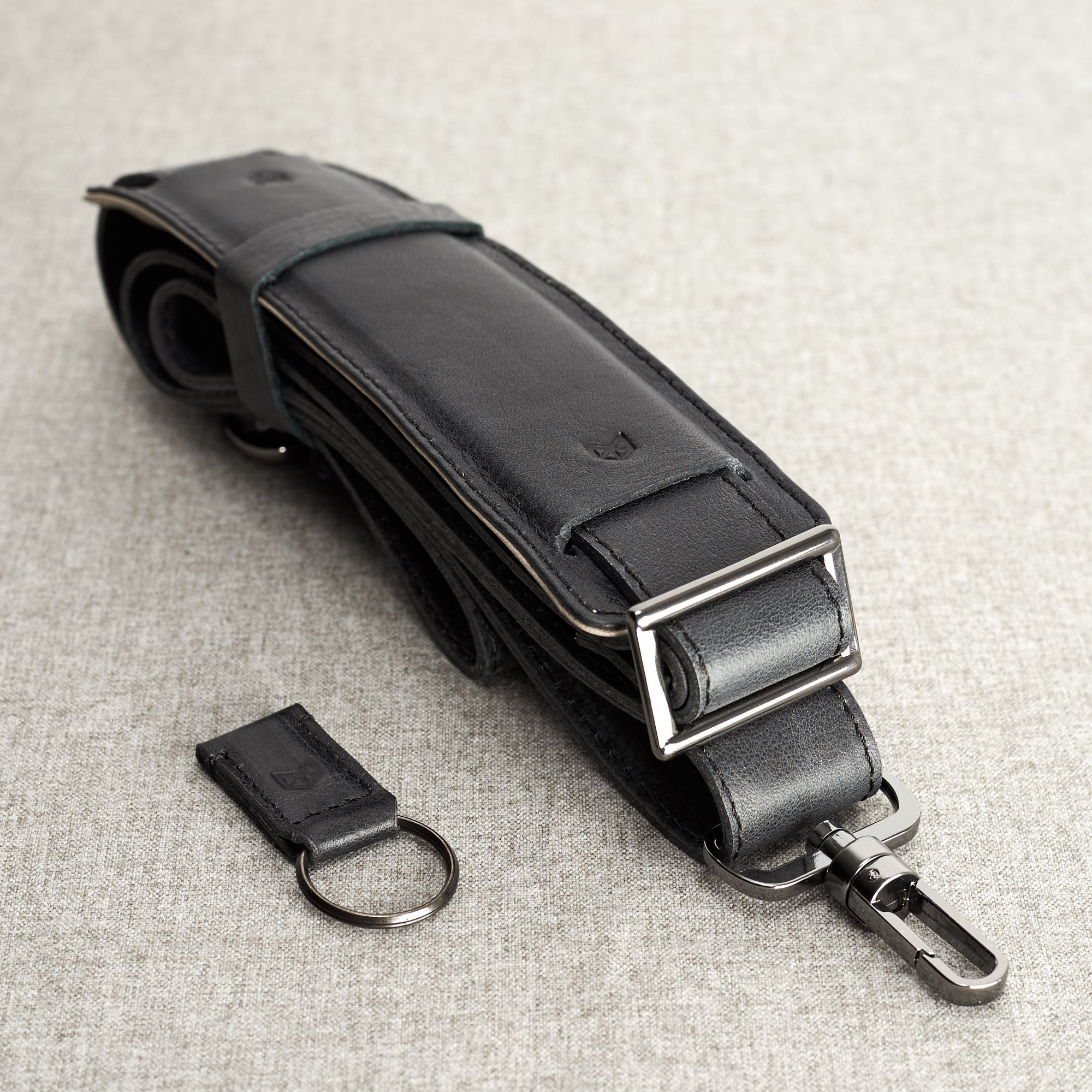 Black leather shoulder strap and key chain holder detail. Black leather workbag. Unique minimalist mens briefcase 