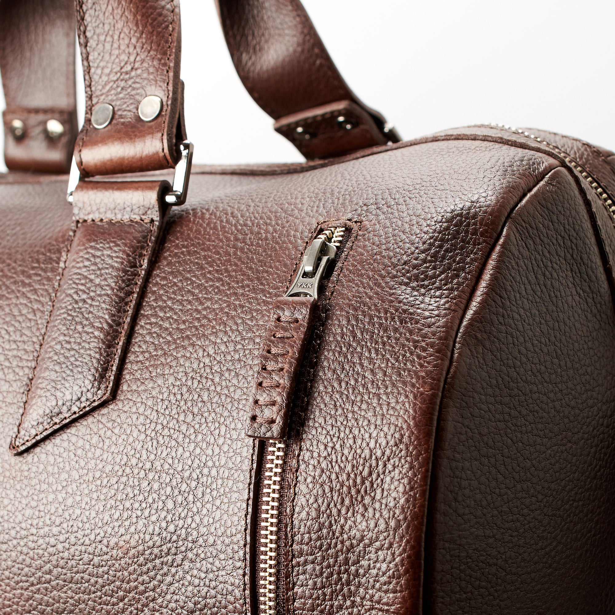 YKK metallic zippers. Dark brown leather carryall bag. Mens travel weekender bag