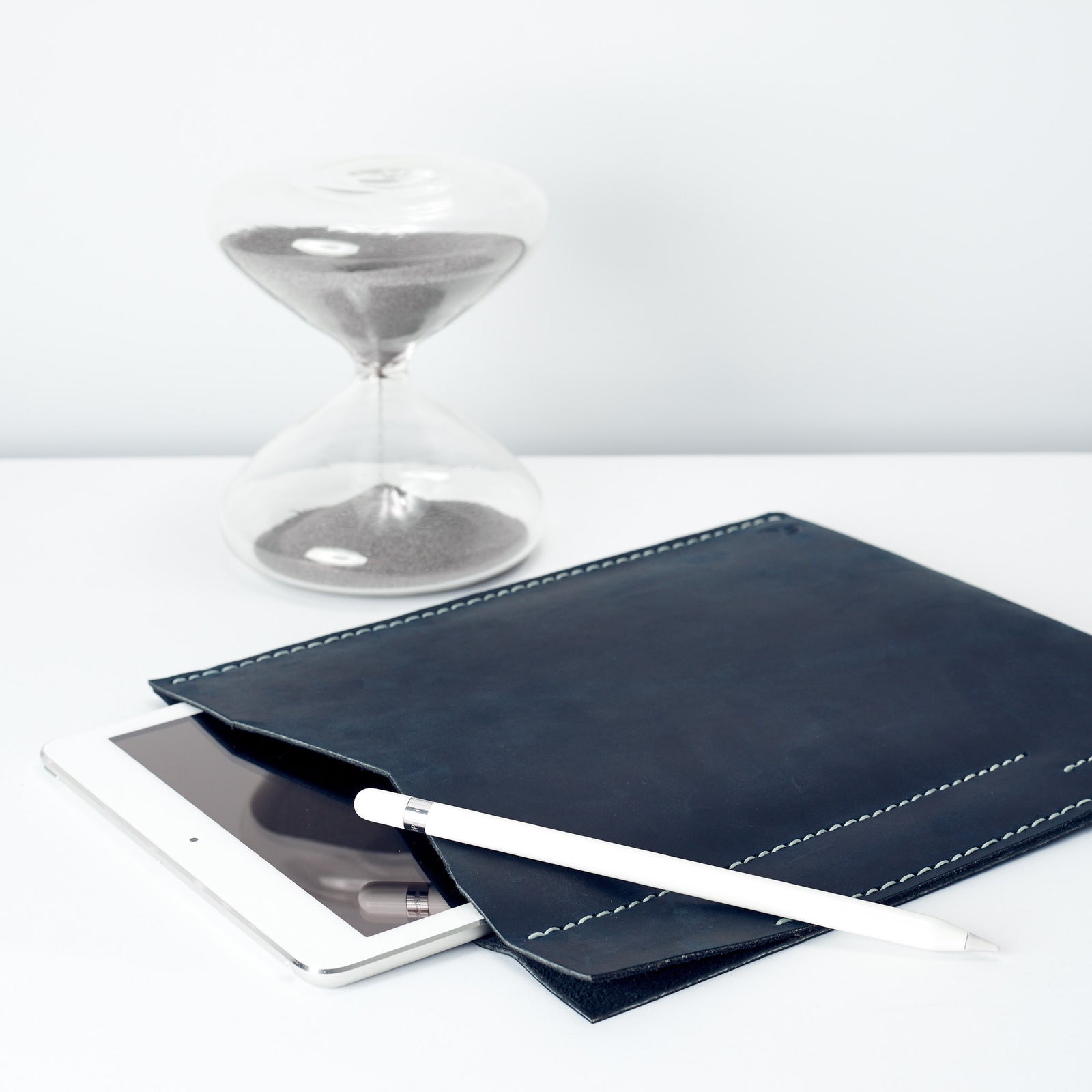 iPad pro blue sleeve on a table with the apple pencil 