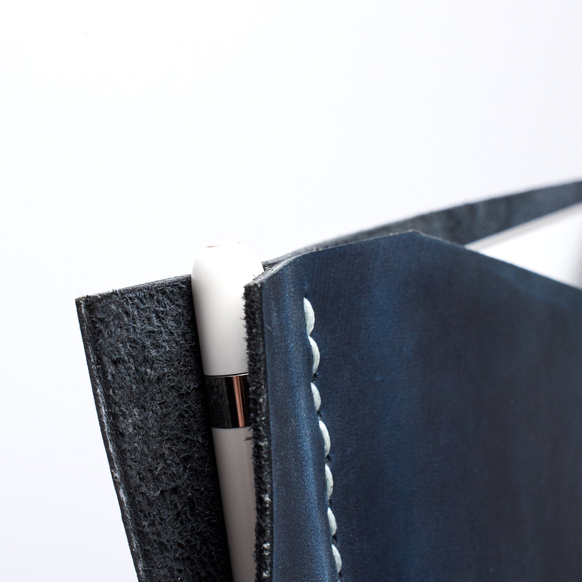 Apple pencil detail. Blue iPad pro leather case with pen holder. Soft leather interior