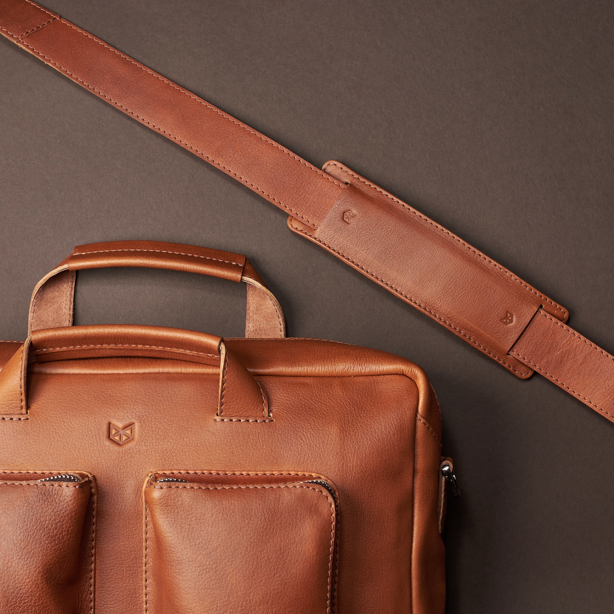 Strap styling. Tan handmade leather messenger bag for Men by Capra Leather. Tech bag, mens weekender bag 