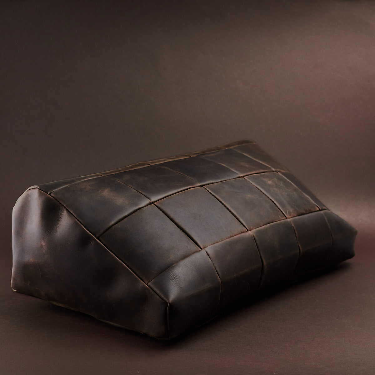 Angle view. Ergonomic under desk footrest cover in brown by Capra Leather