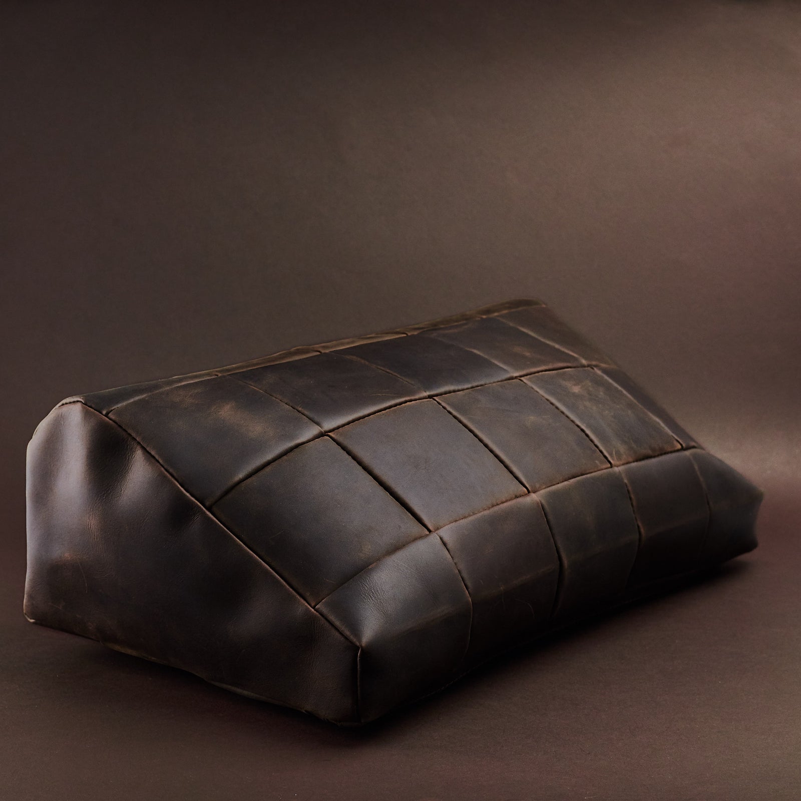 Angle view. Ergonomic under desk footrest cover in brown by Capra Leather