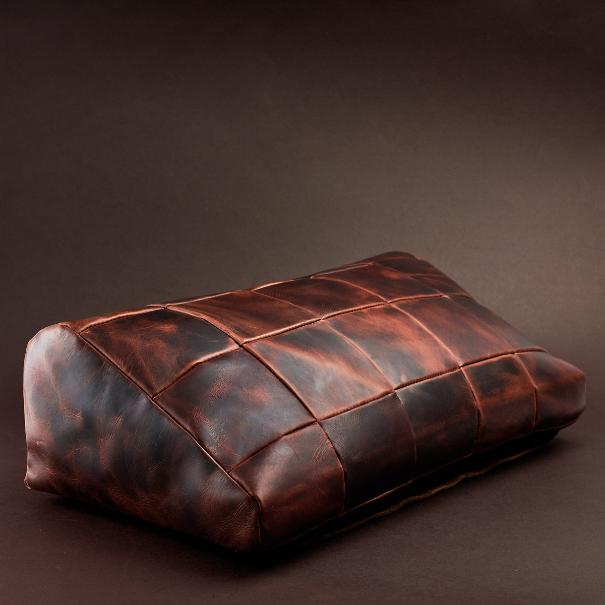 Angle view. Ergonomic under desk footrest cover in distressed cognac by Capra Leather