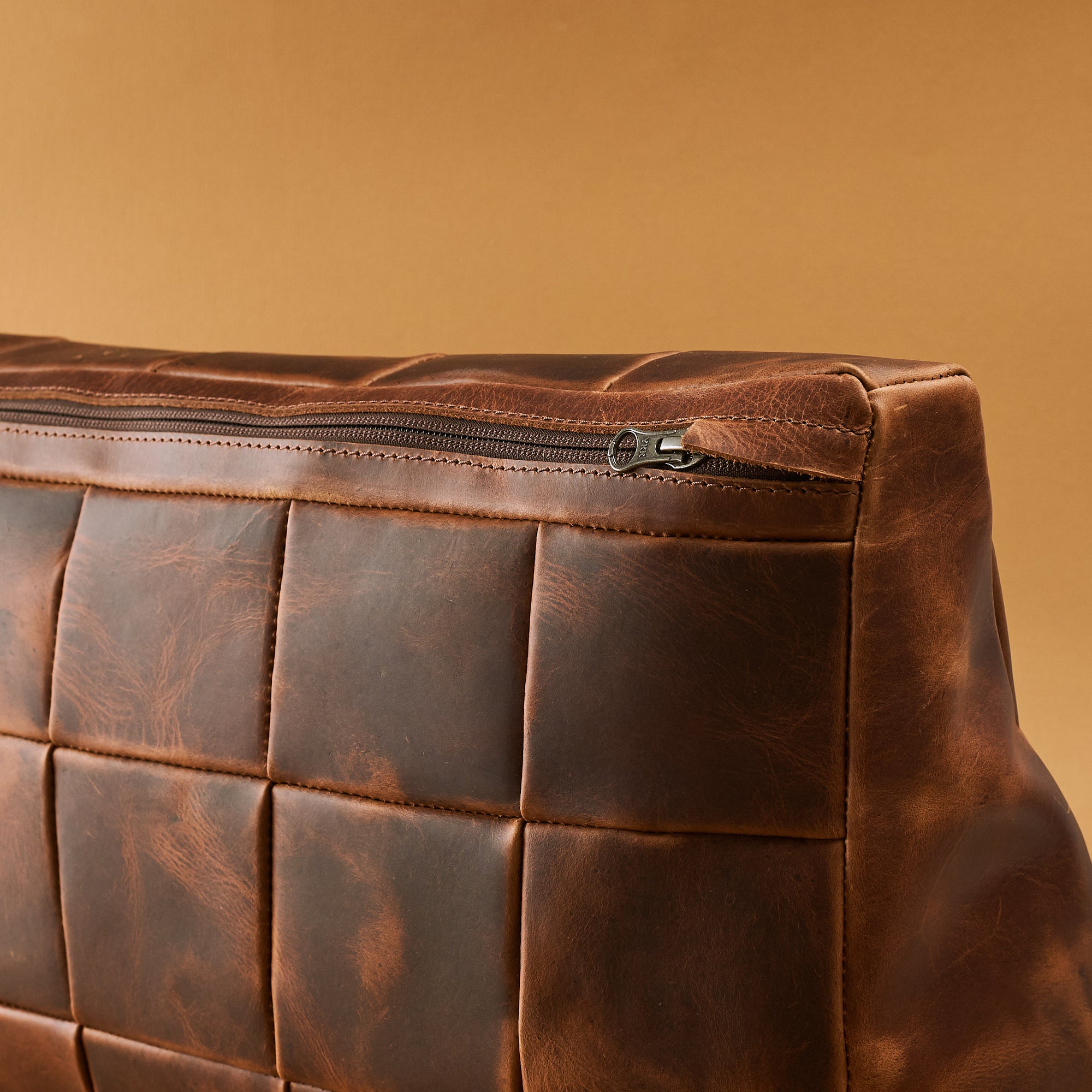 Zipper detail. Ergonomic under desk footrest cover in distressed tan by Capra Leather