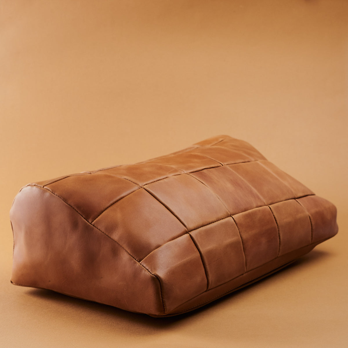 Angle view Cover. Ergonomic under desk footrest cover in tan by Capra Leather