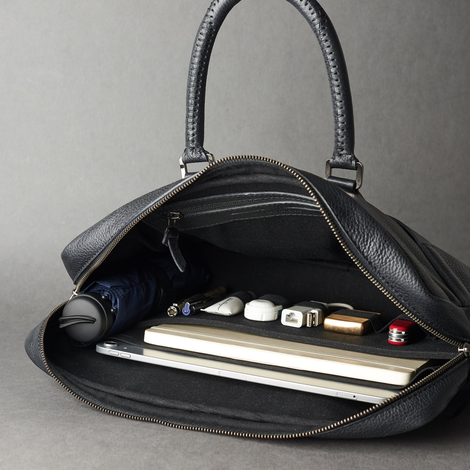 Style view, model holding bussiness document portfolio bag .Black leather briefcase laptop bag for men. Gazeli laptop briefcase by Capra Leather.