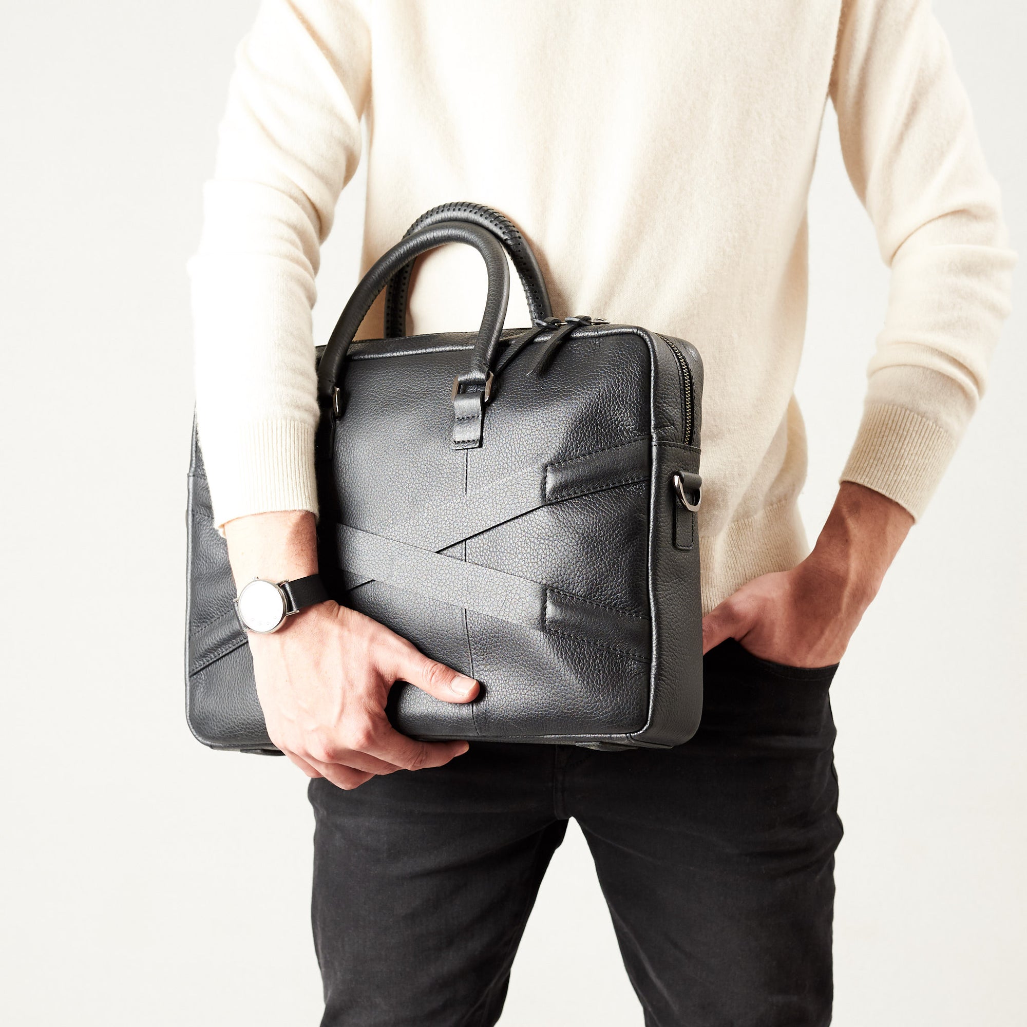Style model holding crossbody with hands. Black leather briefcase laptop bag for men. Gazeli laptop briefcase by Capra Leather.