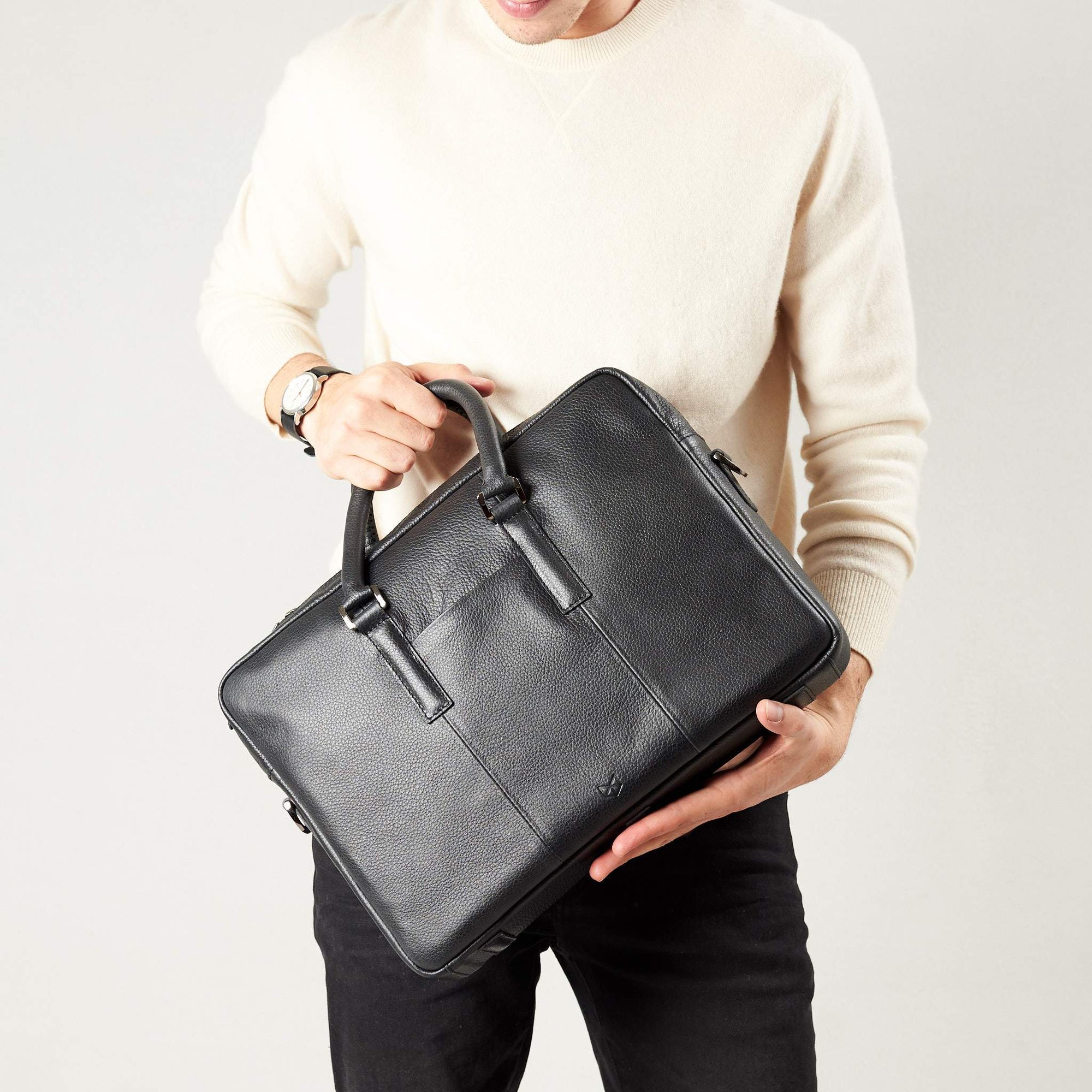 Briefcase with handmade straps in use by model. Black leather briefcase laptop bag for men. Gazeli laptop briefcase by Capra Leather