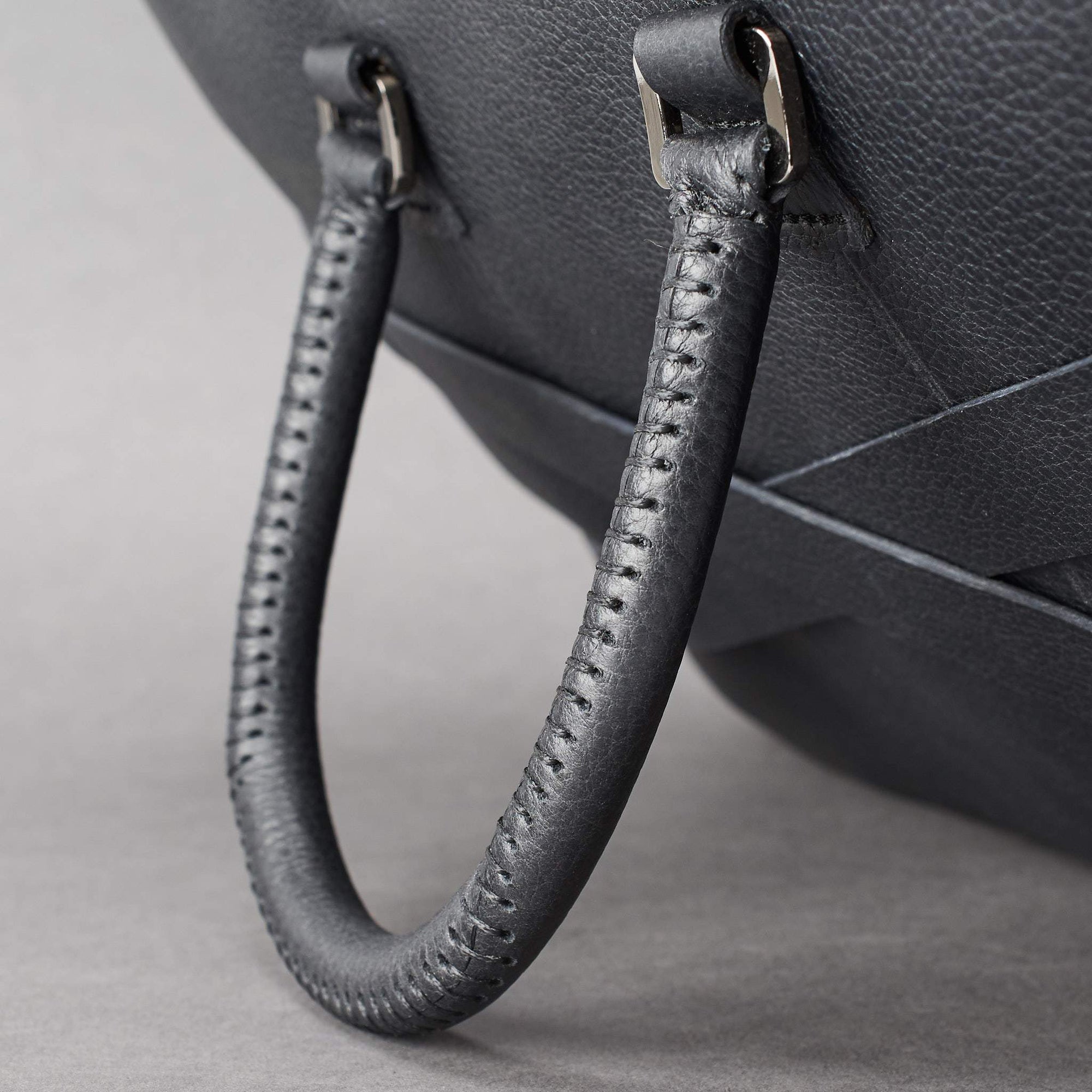Hand stitch cylindrical handle detail. Black leather briefcase laptop bag for men. Gazeli laptop briefcase by Capra Leather.