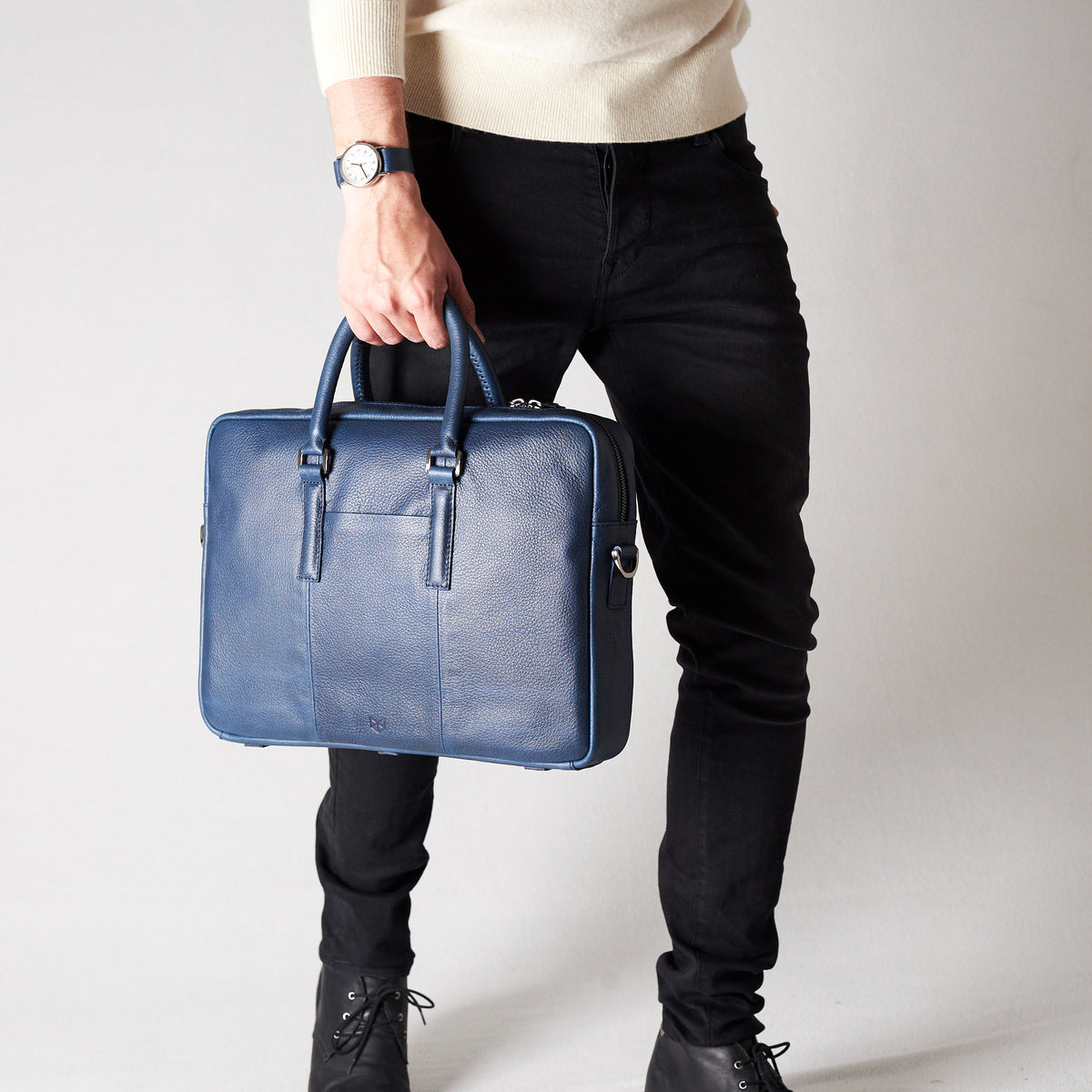 Style view, model holding bussiness document portfolio bag .Blue leather briefcase laptop bag for men. Gazeli laptop briefcase by Capra Leather.