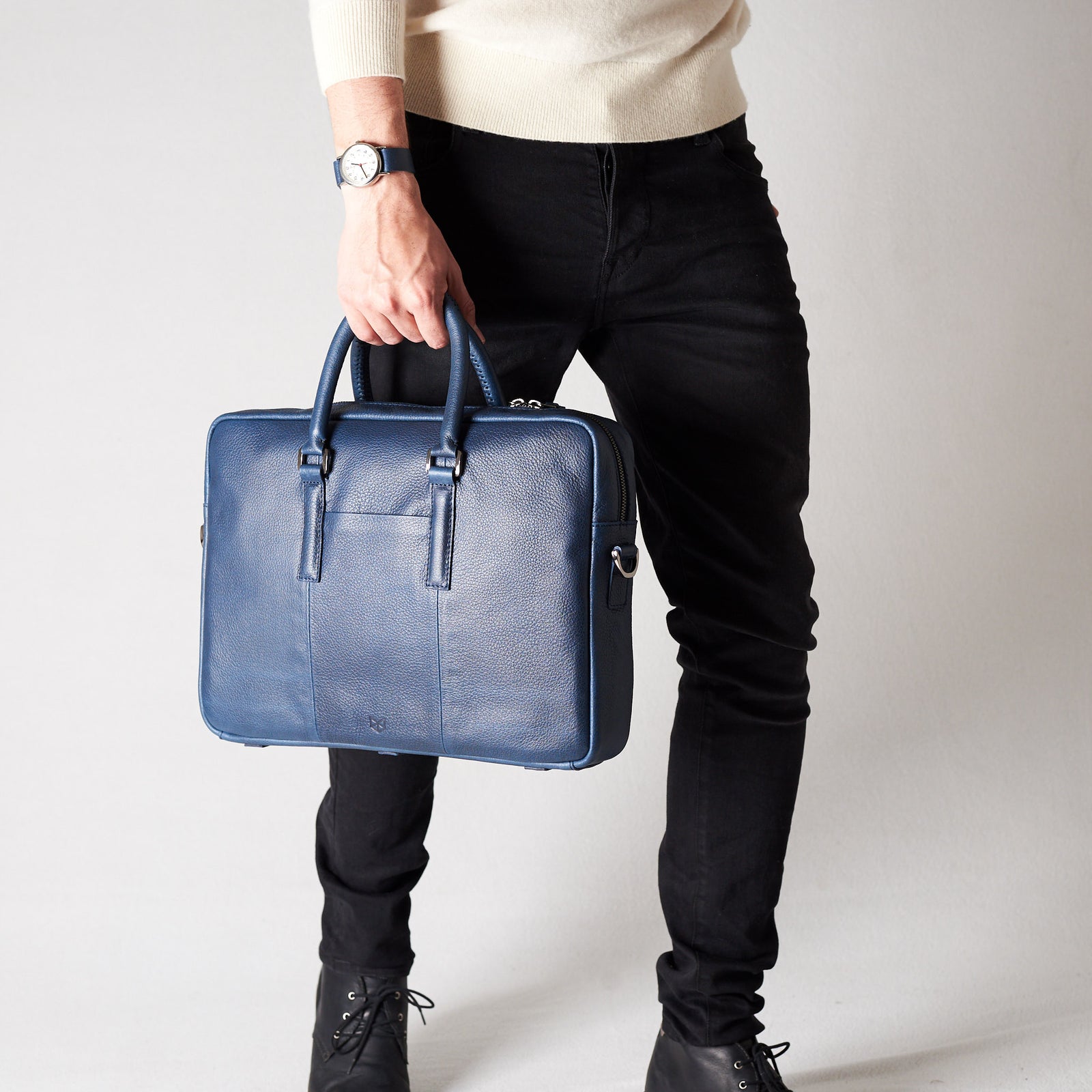 Style view, model holding bussiness document portfolio bag .Blue leather briefcase laptop bag for men. Gazeli laptop briefcase by Capra Leather.