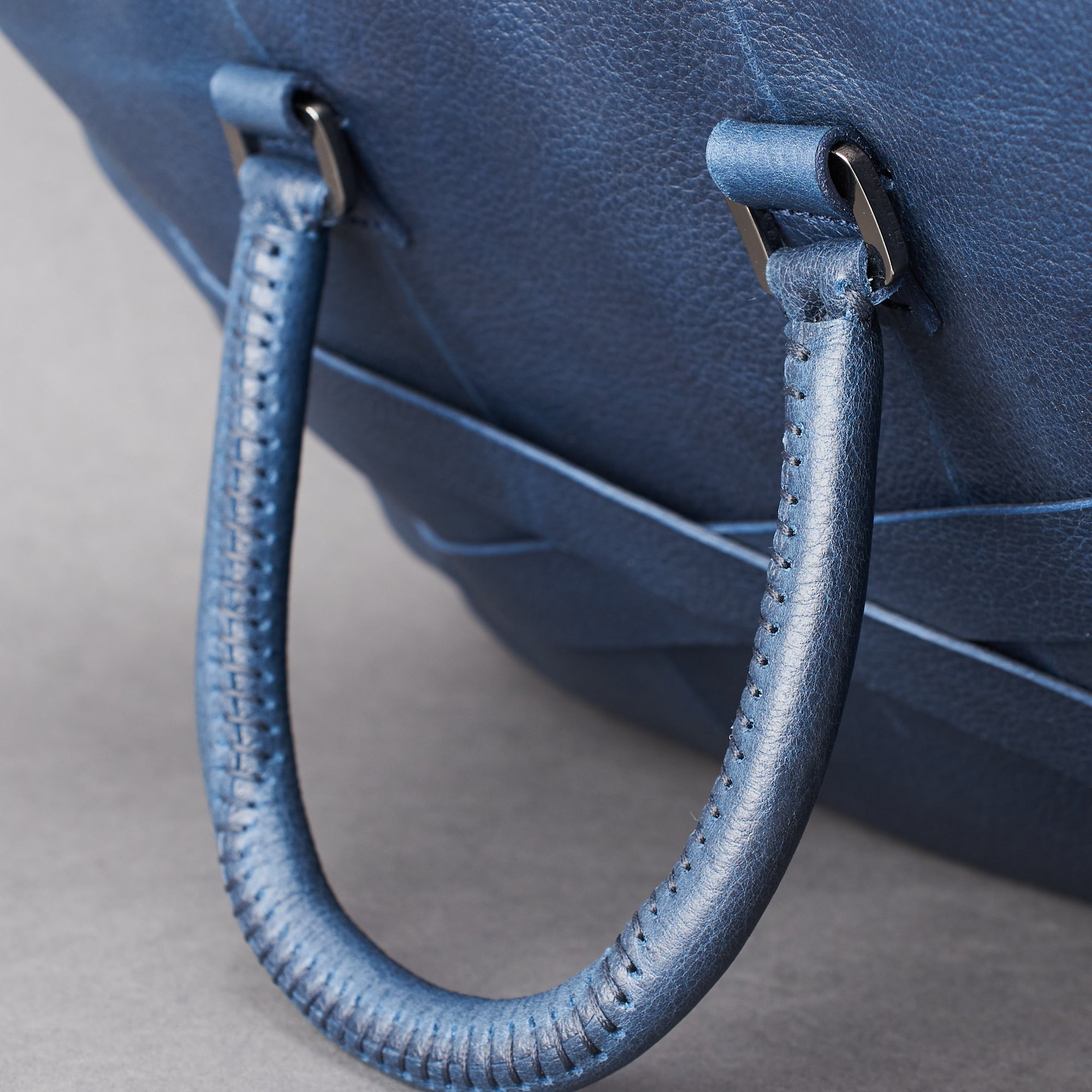 Hand stitch cylindrical handle detail. Blue leather briefcase laptop bag for men. Gazeli laptop briefcase by Capra Leather.
