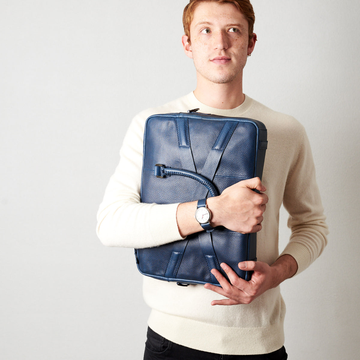 Holding business briefcase. Blue leather briefcase laptop bag for men. Gazeli laptop briefcase by Capra Leather.