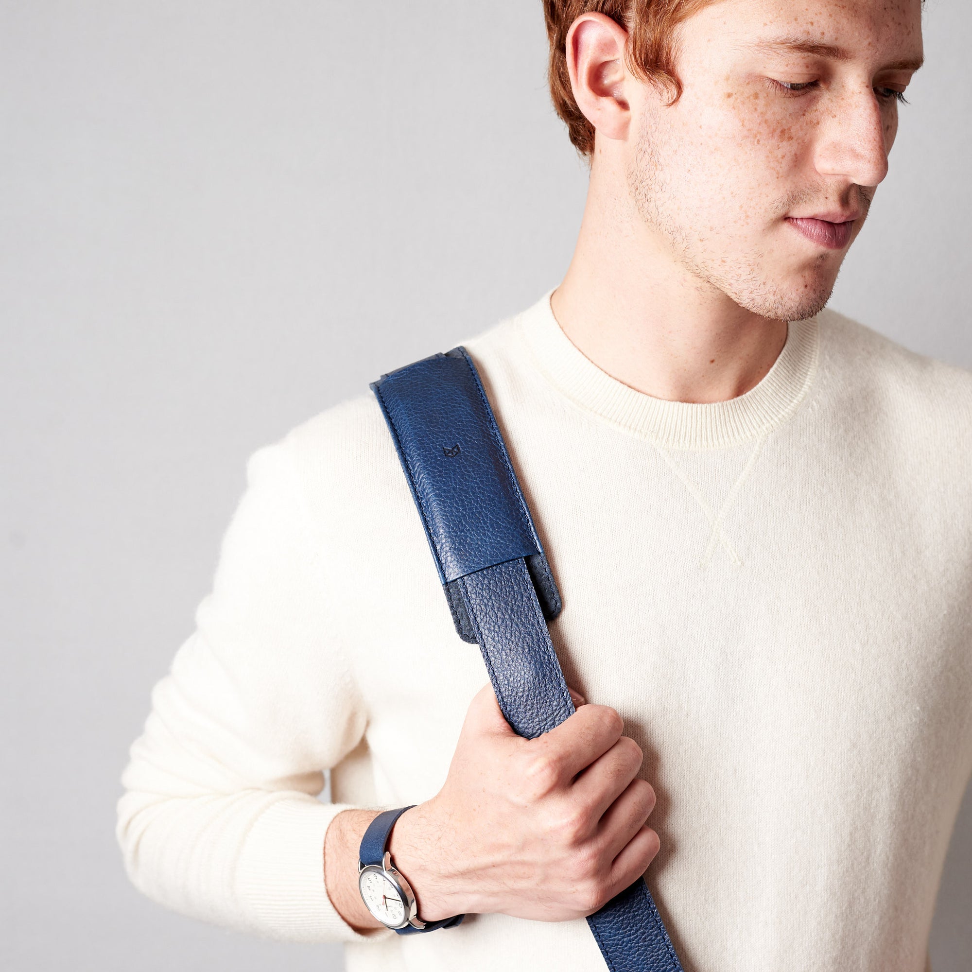 Detail of model wearing minimalist strap design. Blue leather briefcase laptop bag for men. Gazeli laptop briefcase by Capra Leather.