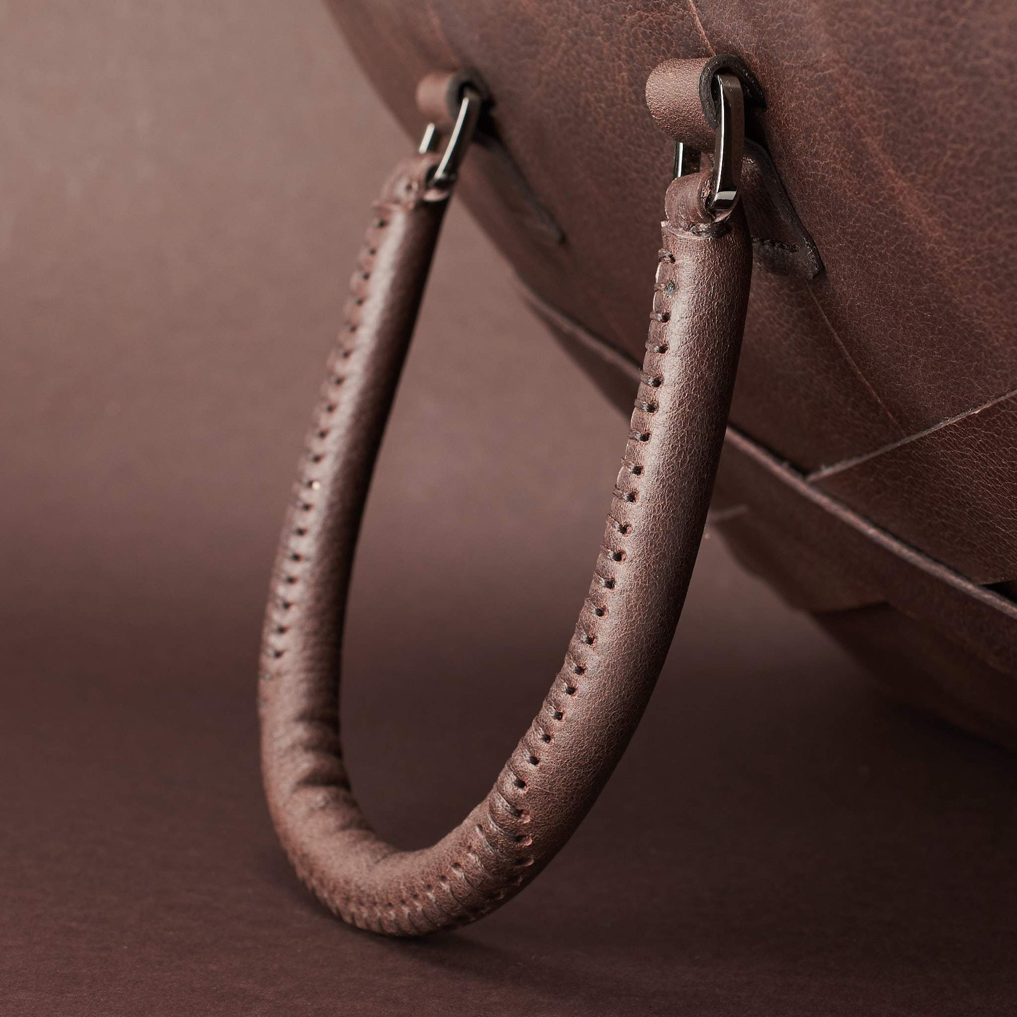 Hand stitch cylindrical handle detail. Dark Brown leather briefcase laptop bag for men. Gazeli laptop briefcase by Capra Leather.