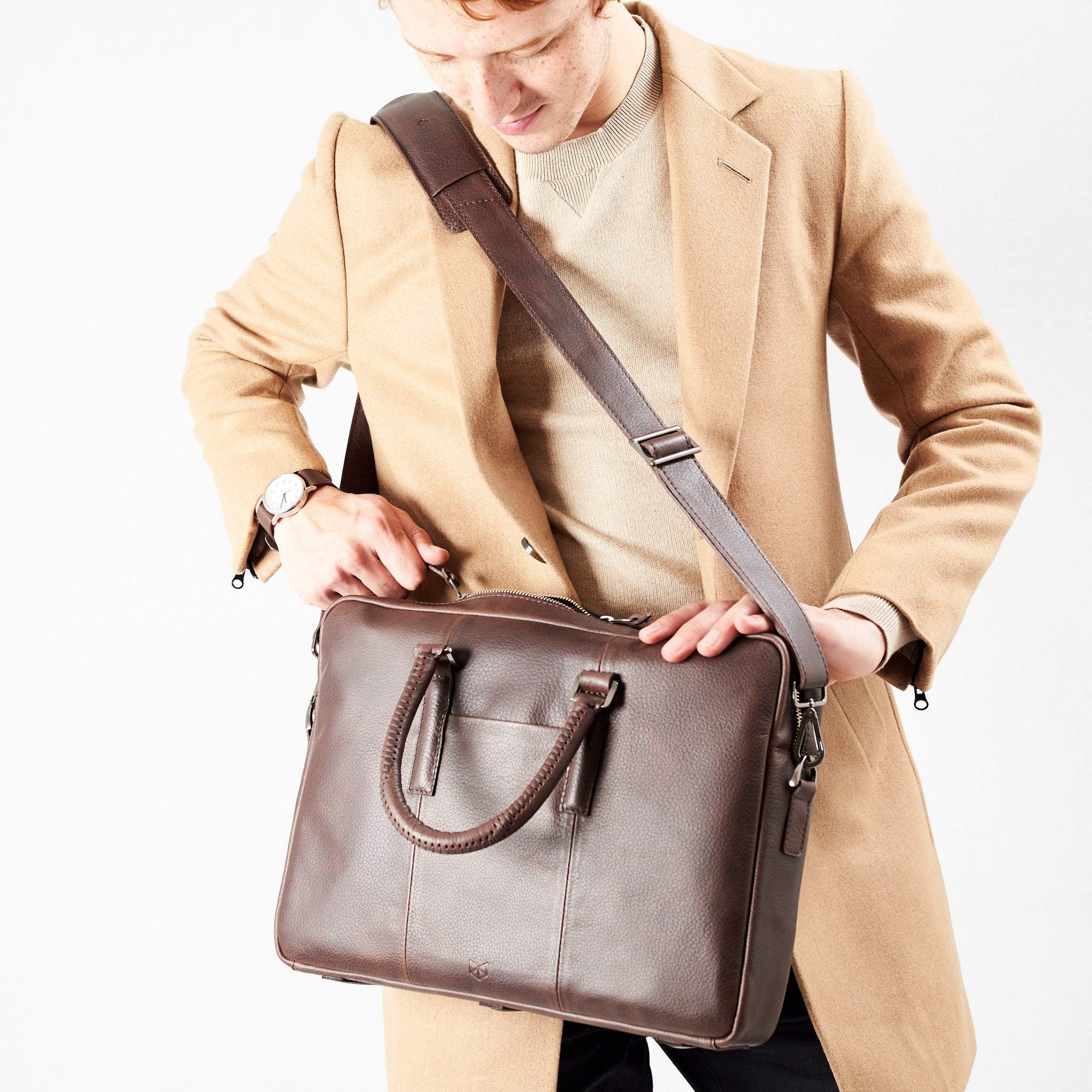 Shoulder bag in use by model. Dark Brown leather briefcase laptop bag for men. Gazeli laptop briefcase by Capra Leather