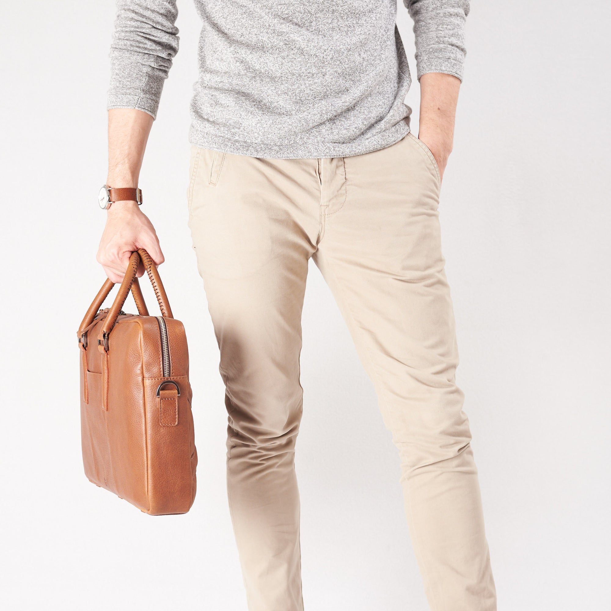 Style view, model holding bussiness document portfolio bag .Tan leather briefcase laptop bag for men. Gazeli laptop briefcase by Capra Leather.