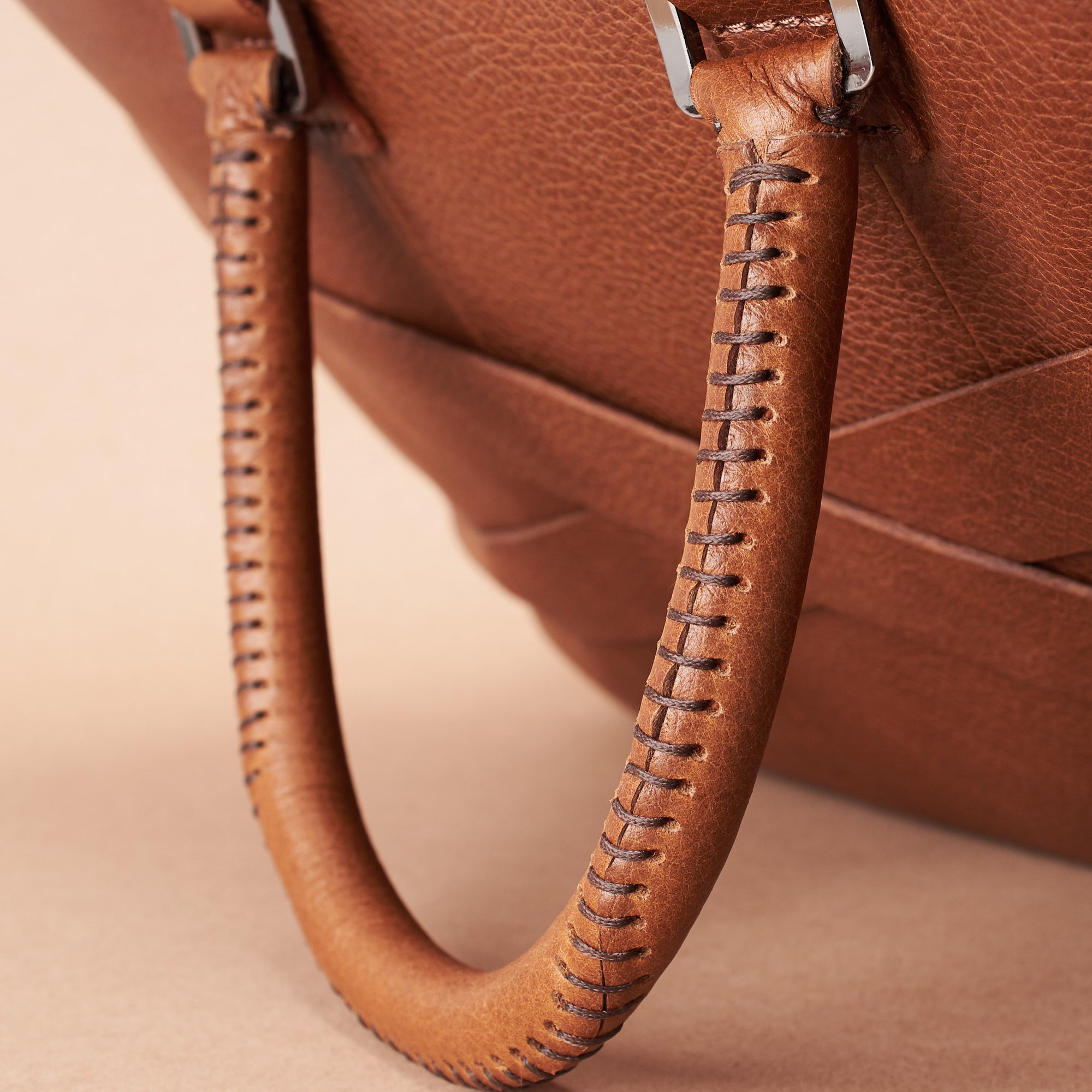 Hand stitch cylindrical handle detail. Tan leather briefcase laptop bag for men. Gazeli laptop briefcase by Capra Leather.