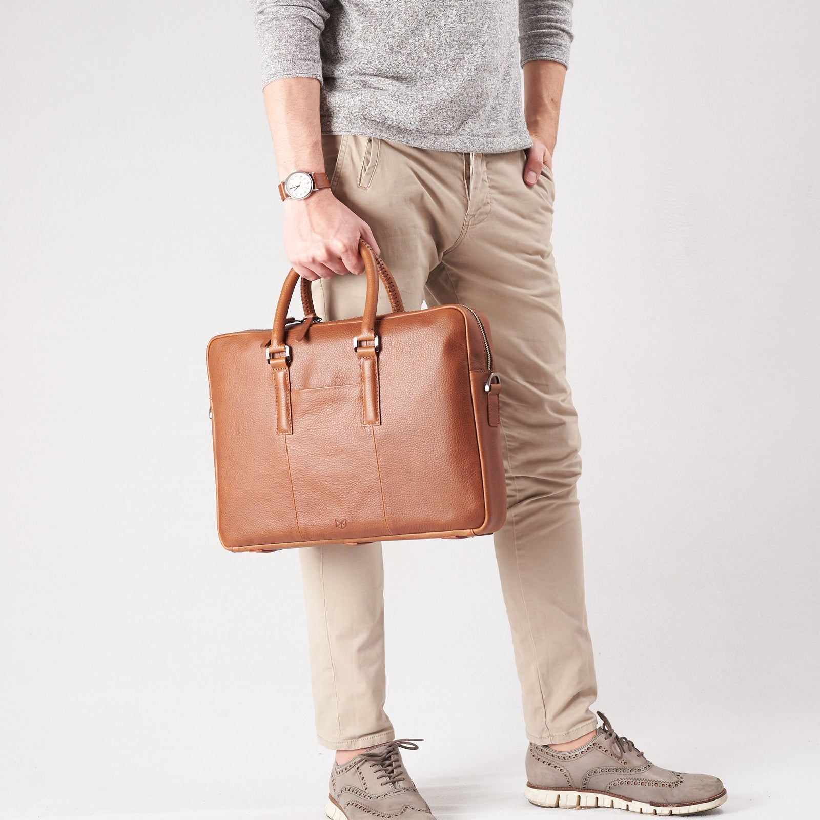 Holding business briefcase. Tan leather briefcase laptop bag for men. Gazeli laptop briefcase by Capra Leather.
