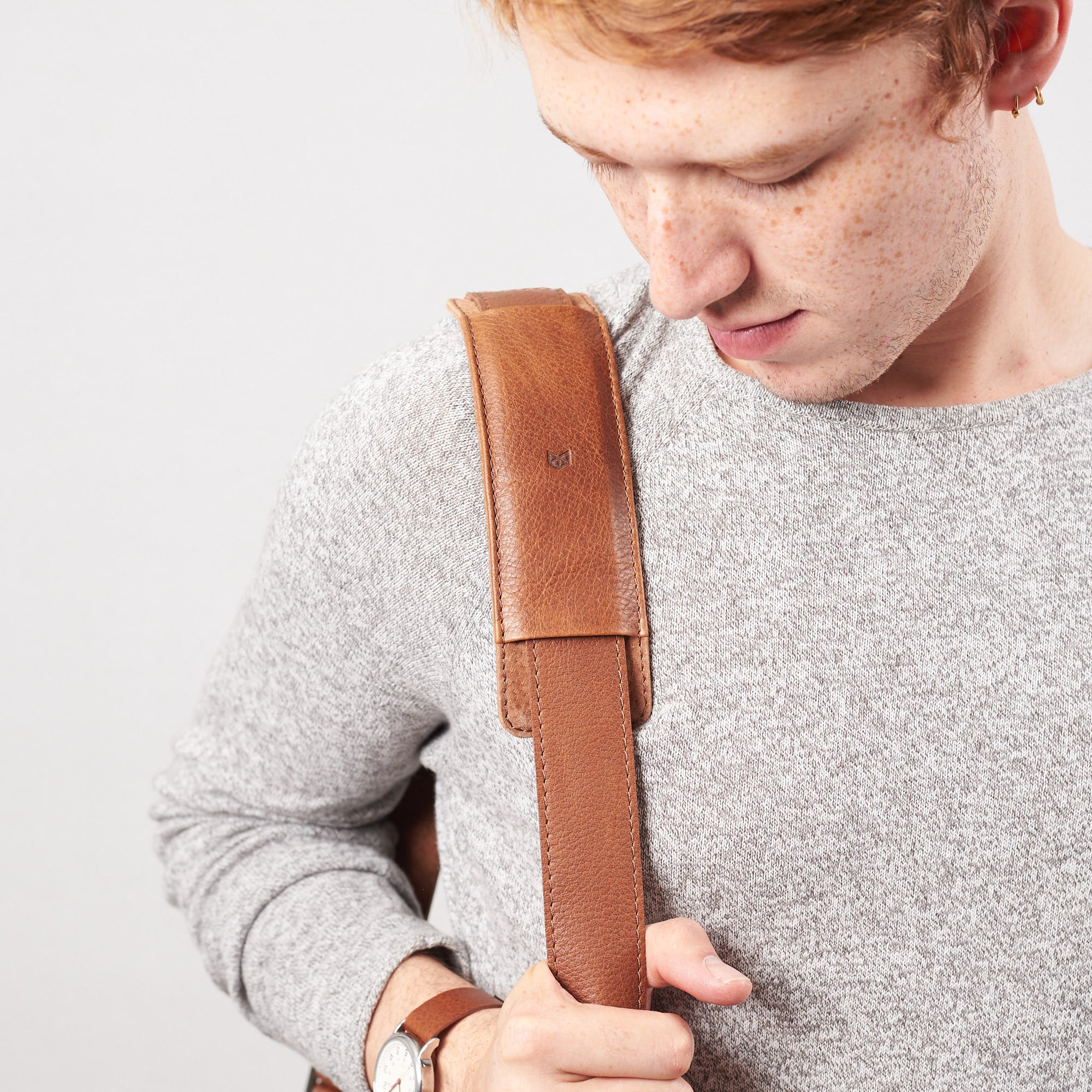 Detail of model wearing minimalist strap design. Tan leather briefcase laptop bag for men. Gazeli laptop briefcase by Capra Leather.