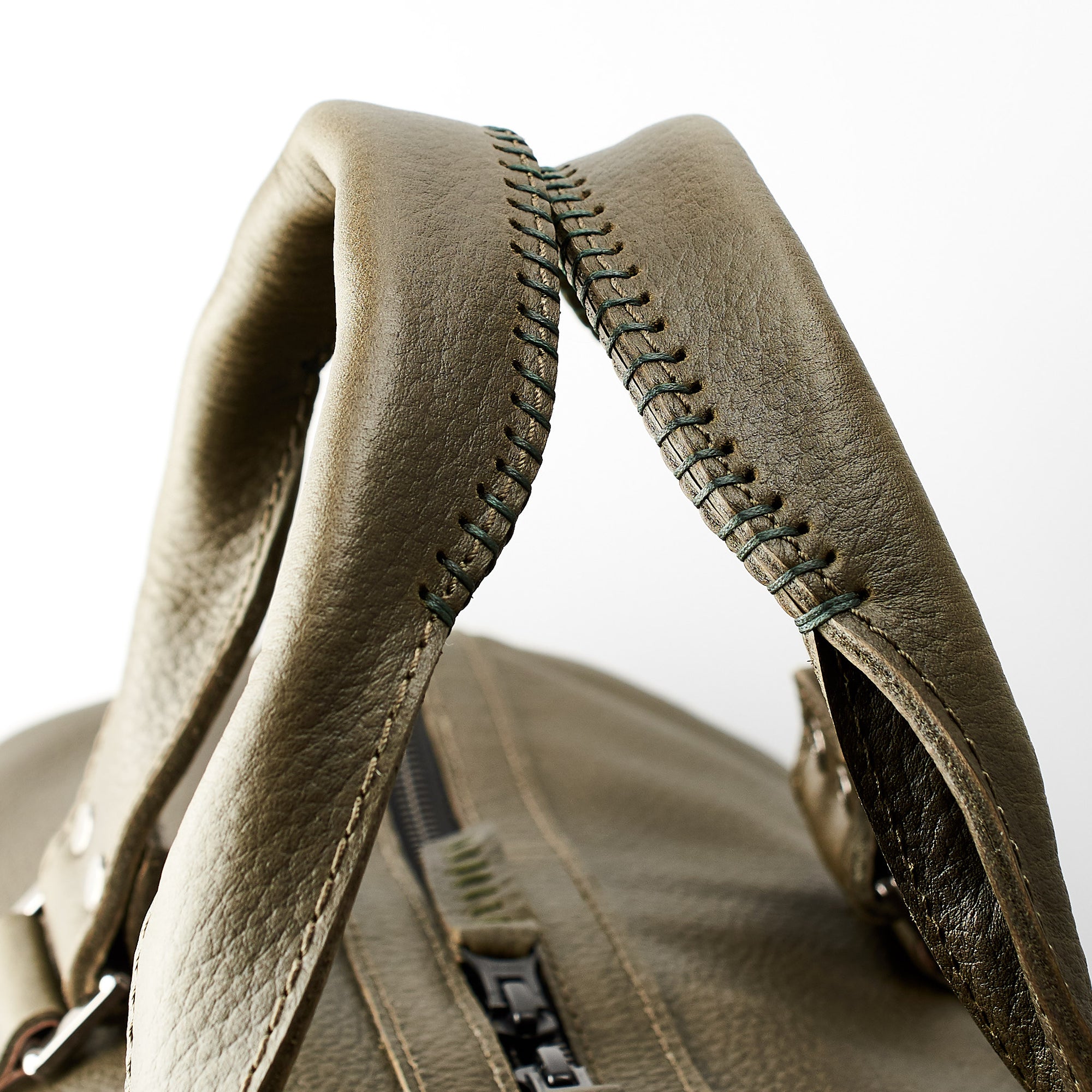 Hand stitched handles. Green leather athletic duffle bag for weekend