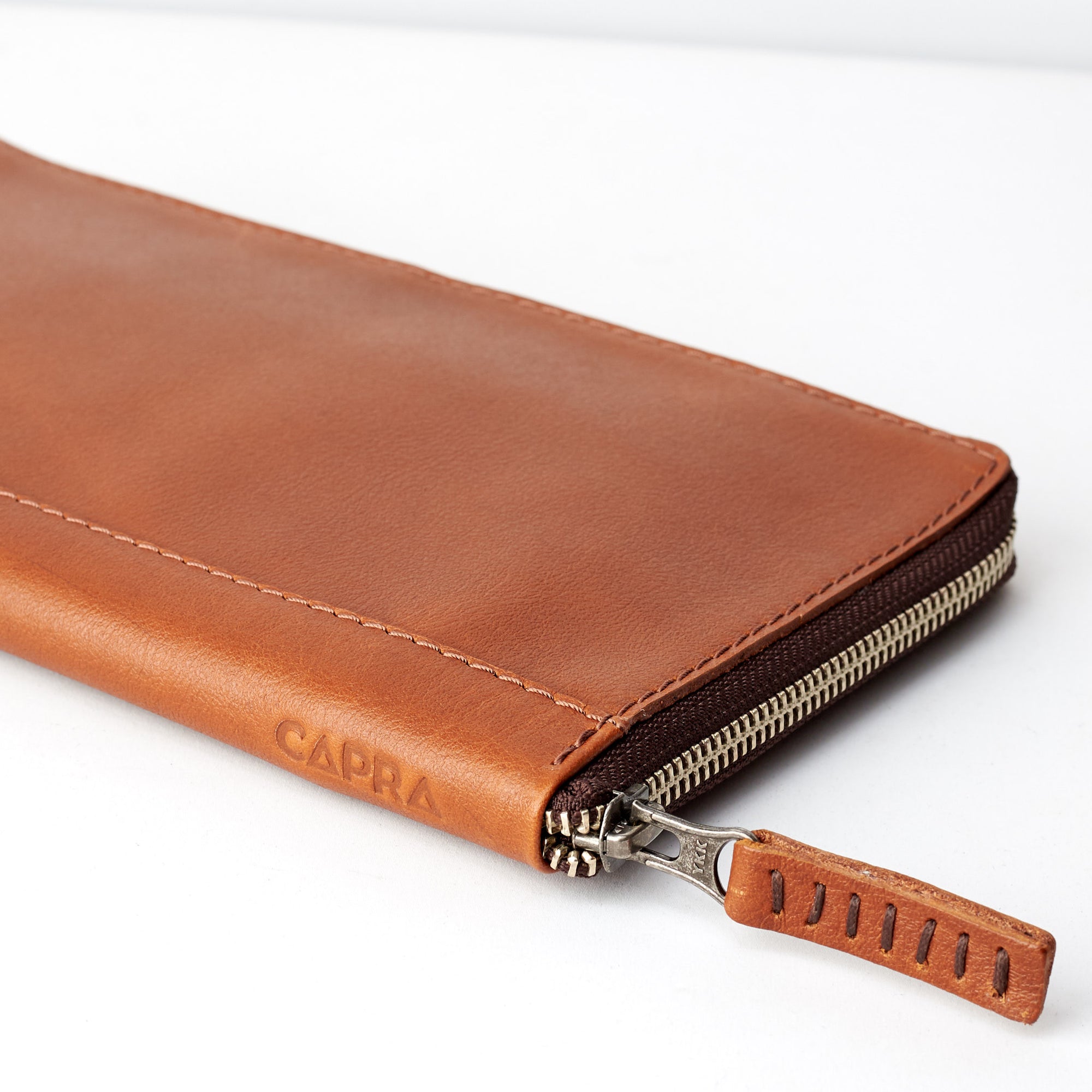 Slider and side view. Tan leather passport holder. Airport travel leather organizer accessories. Leather good craft by Capra Leather.