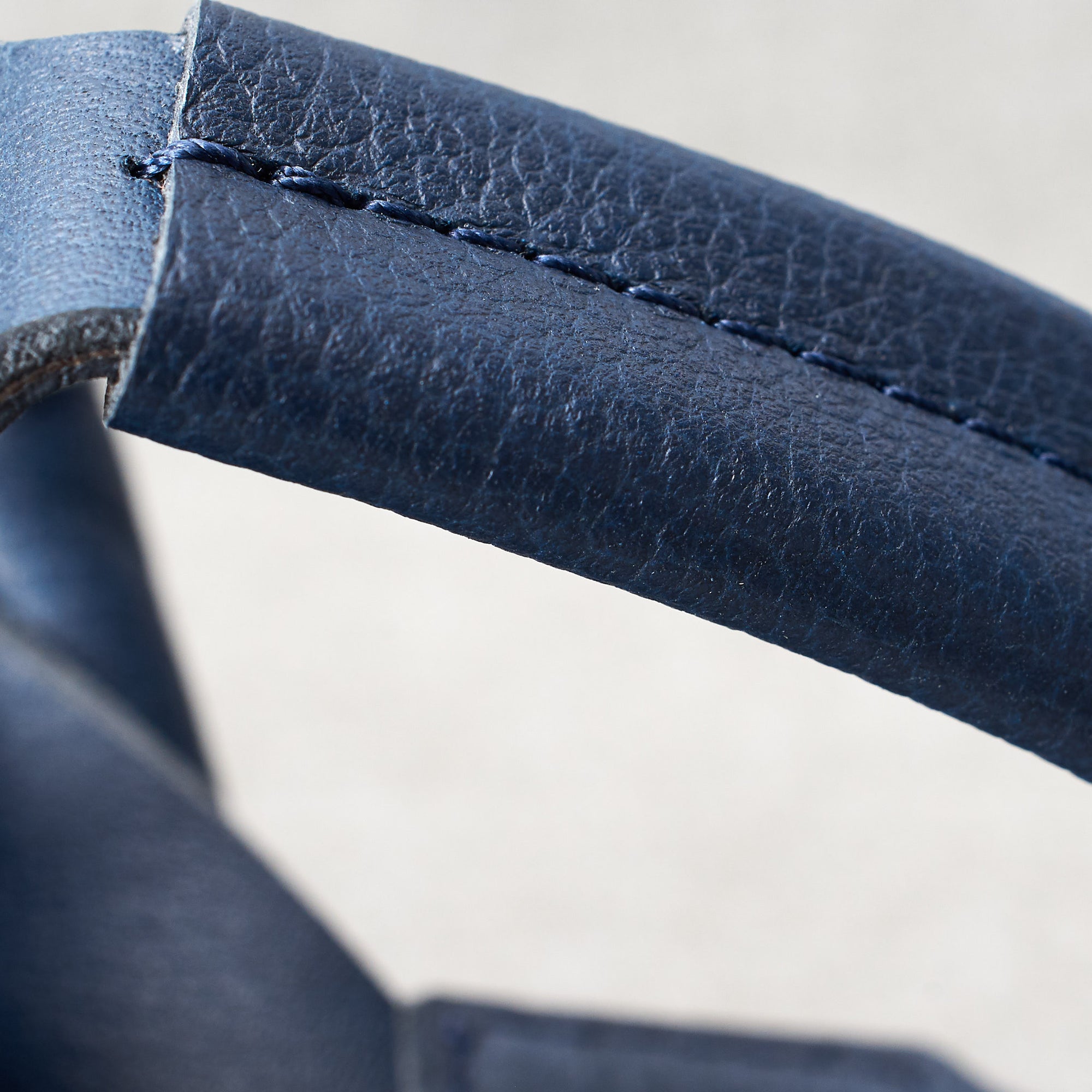 Handle detail. Fenek blue sling bag for men by Capra Leather. Full grain leather handle. 