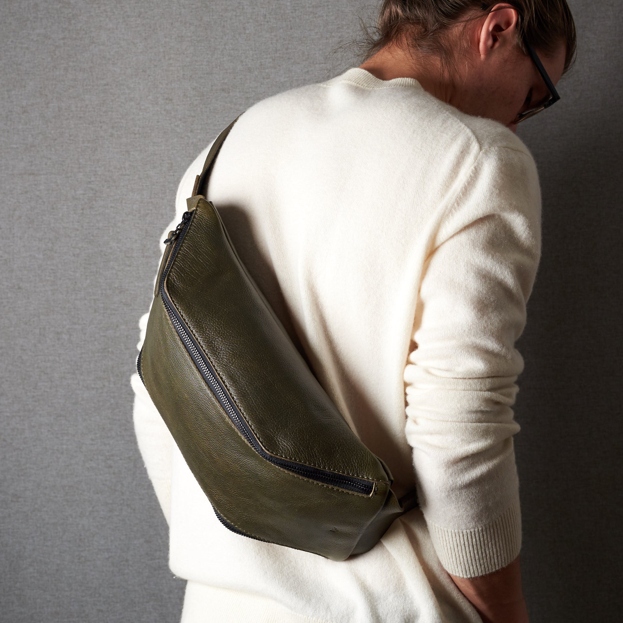 Styling side. Fenek green sling bag for men by Capra Leather. Festival messenger bag with engraving.