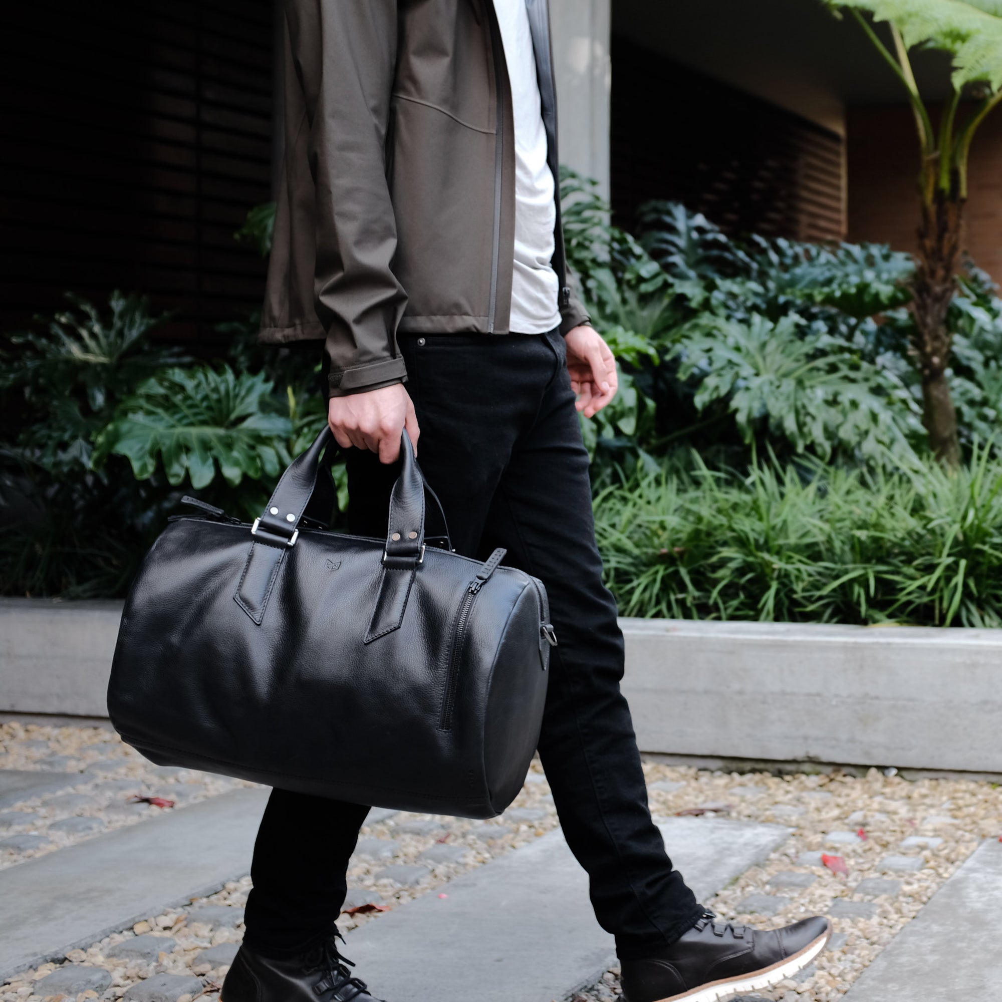 Style outside photo. Black leather duffle handbag for men. Travel designer bag 