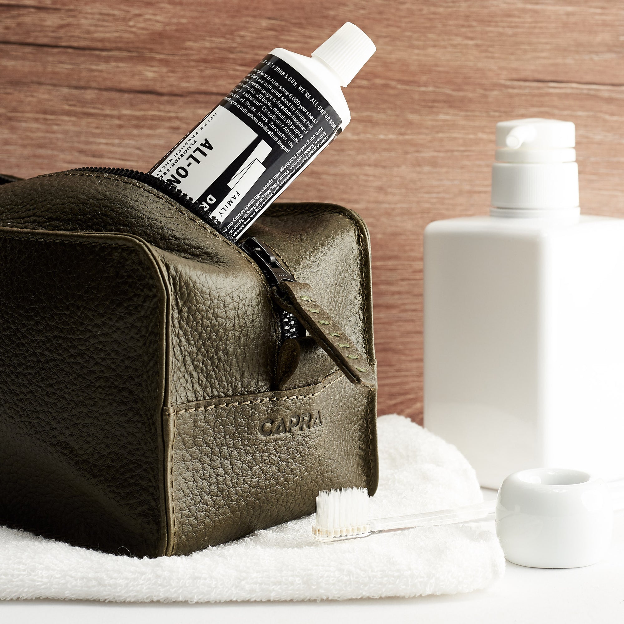 Hotel bathroom. Green leather toiletry, shaving bag with hand stitched handle. Groomsmen gifts