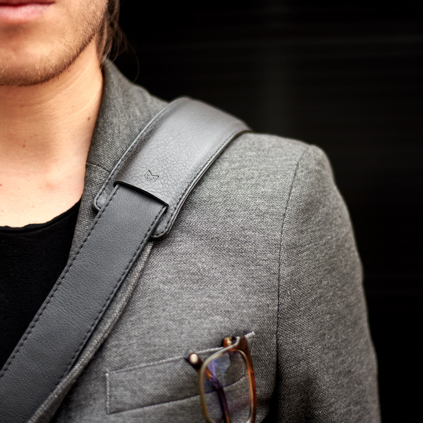 Close up shoulder padded strap. Black leather soft briefcase. Unique designer mens bag