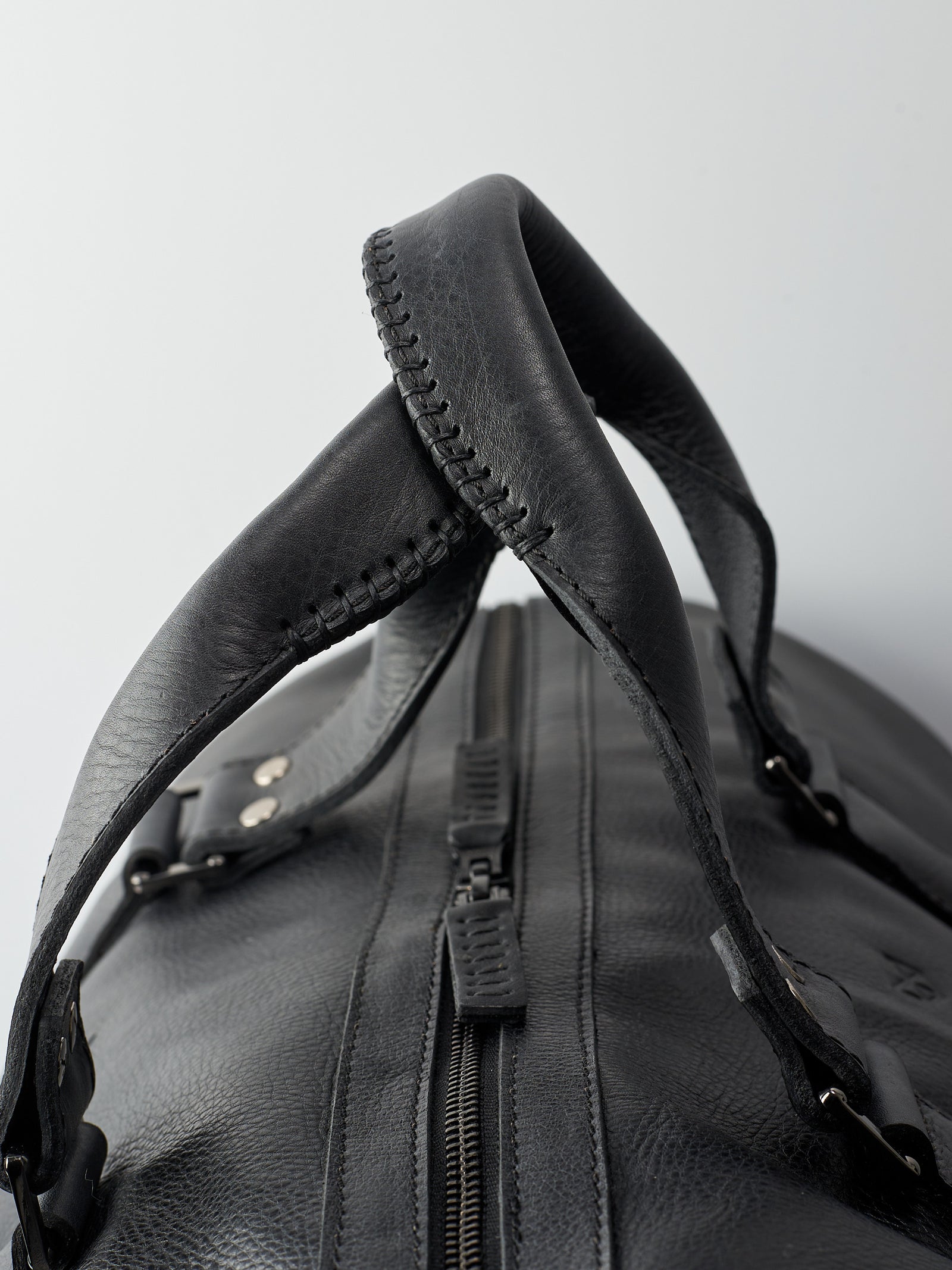 Hand stitched handles. Black leather athletic duffle bag for weekend