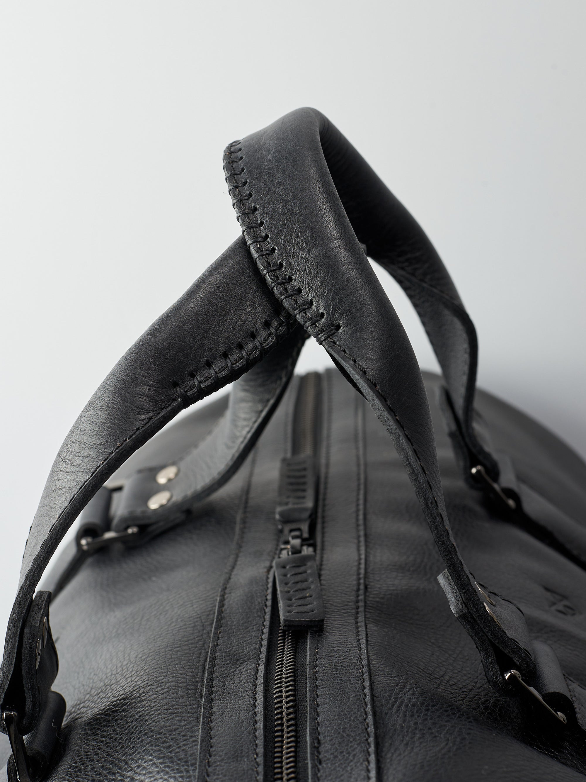 Hand stitched handles. Black leather athletic duffle bag for weekend