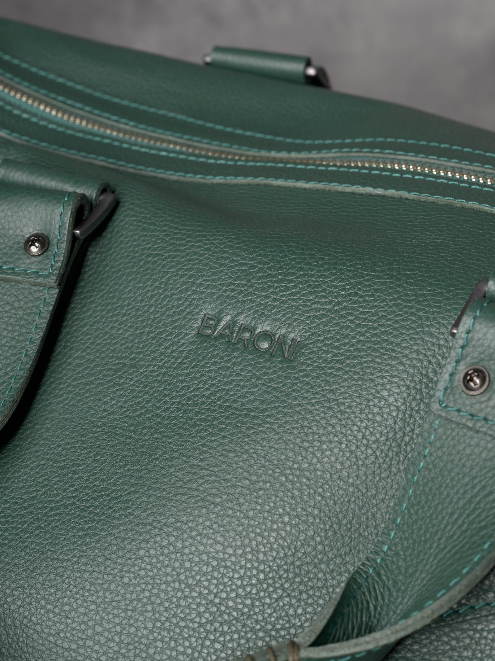 Detailed shot of the pebbled forest green leather surface featuring the "BARONI" name subtly embossed.