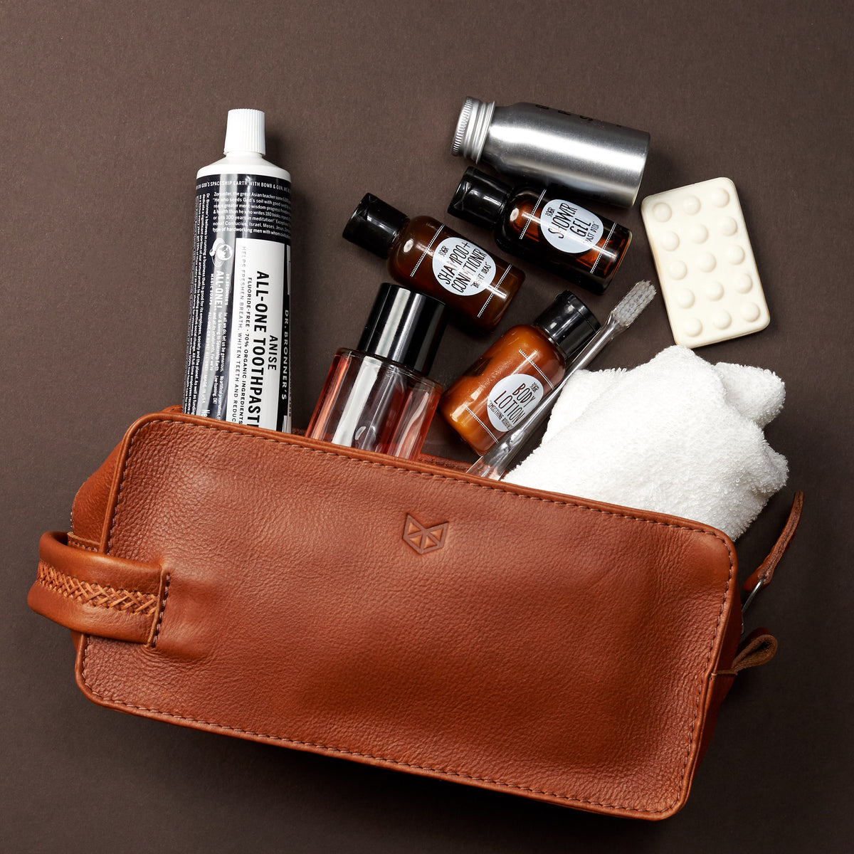 Styling products . Tan leather toiletry, shaving bag with hand stitched handle. Groomsmen gifts. Leather good crafted by Capra Leather 